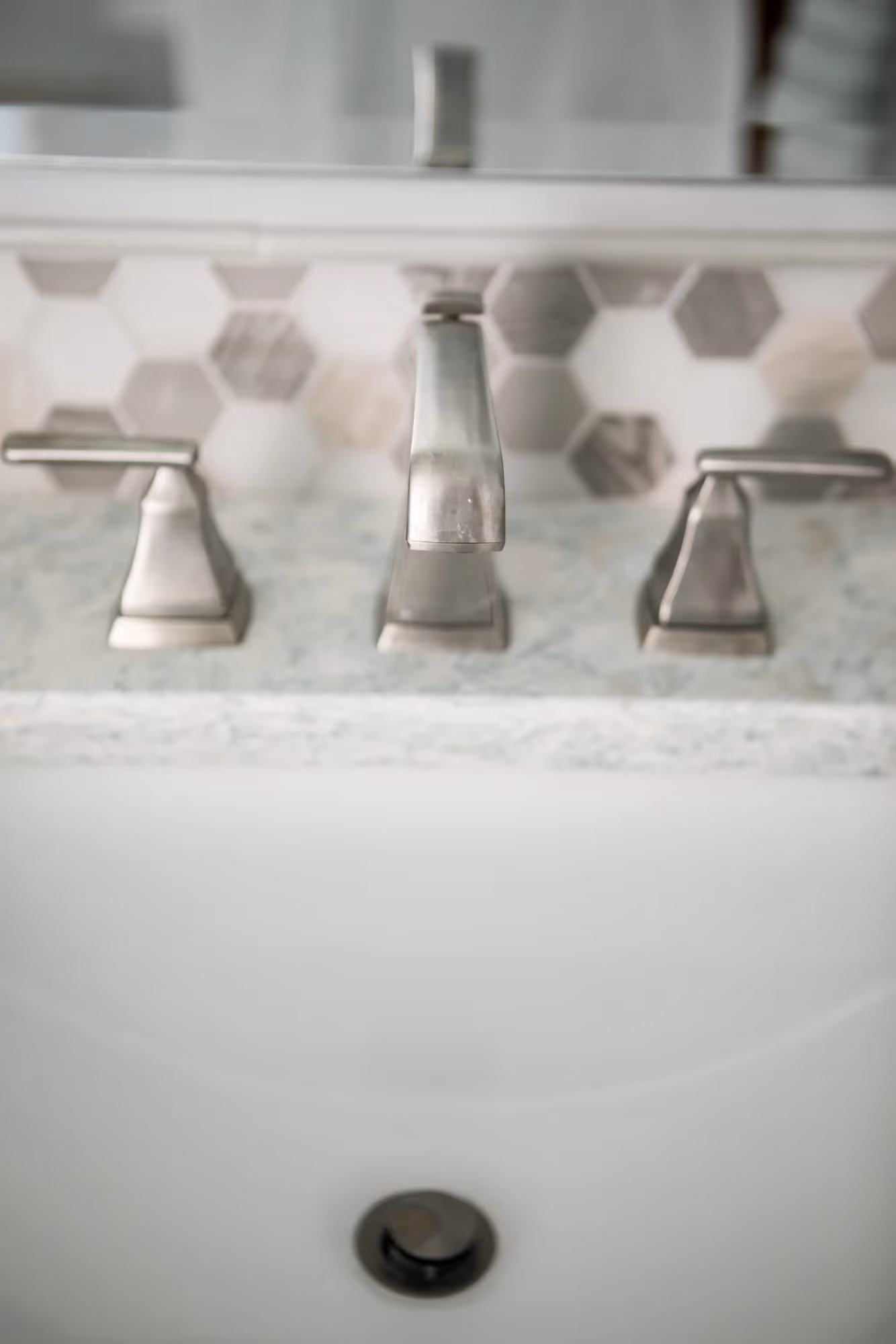 Bathroom sink with dual faucets and mirrors.