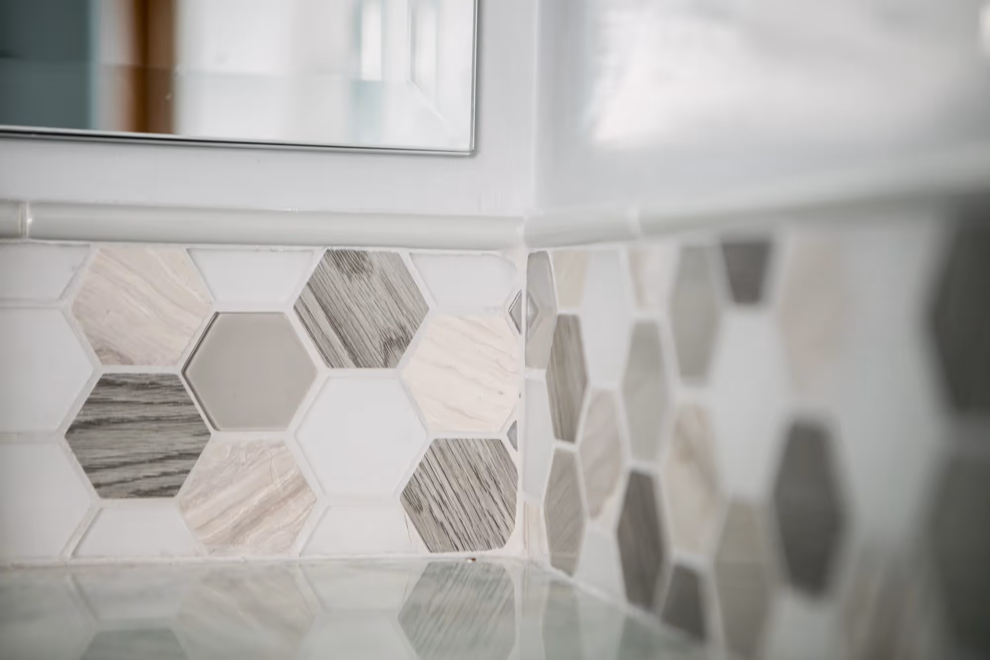 Close-up of hexagonal mosaic wall tiles in a bathroom.