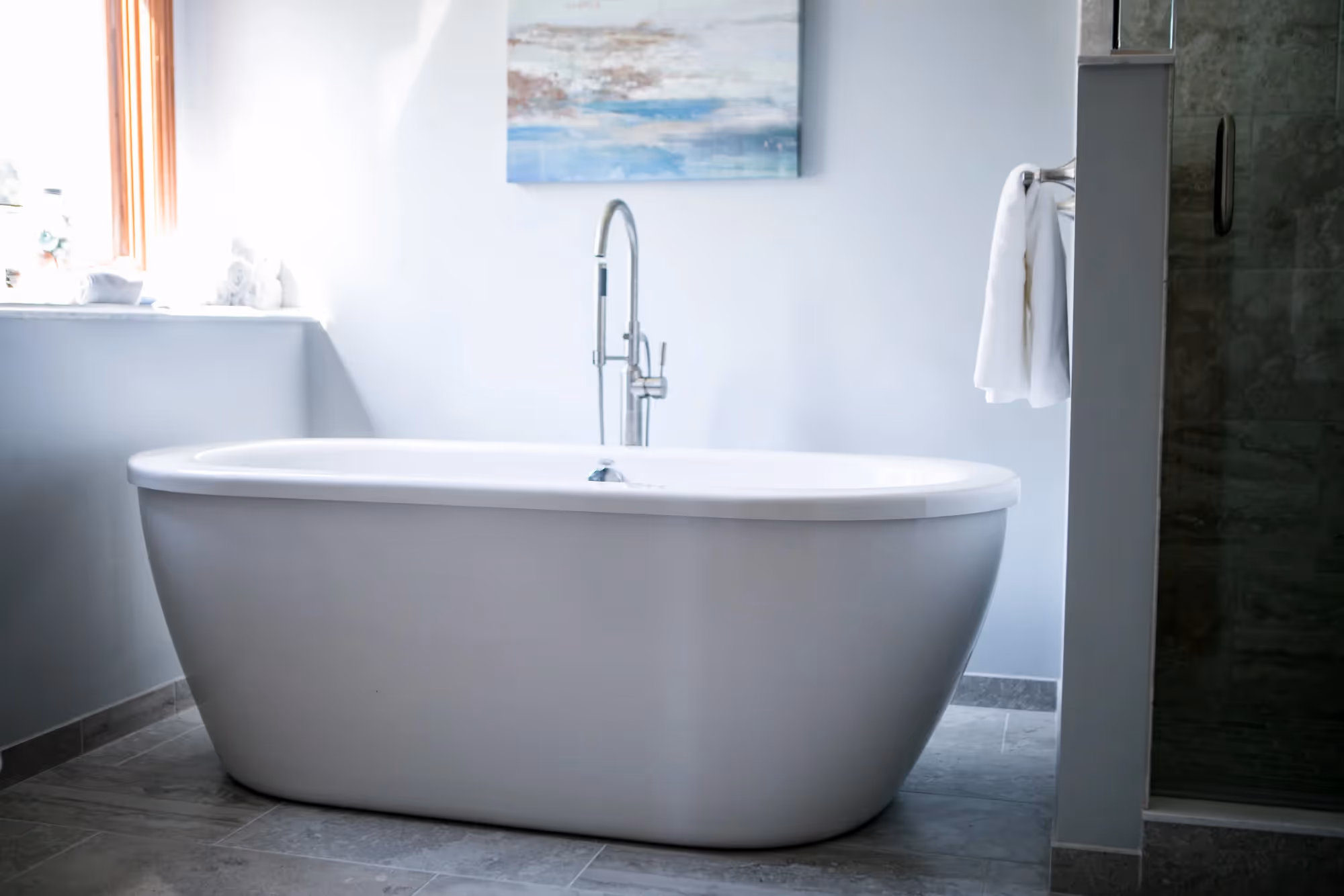 Freestanding bathtub near large window