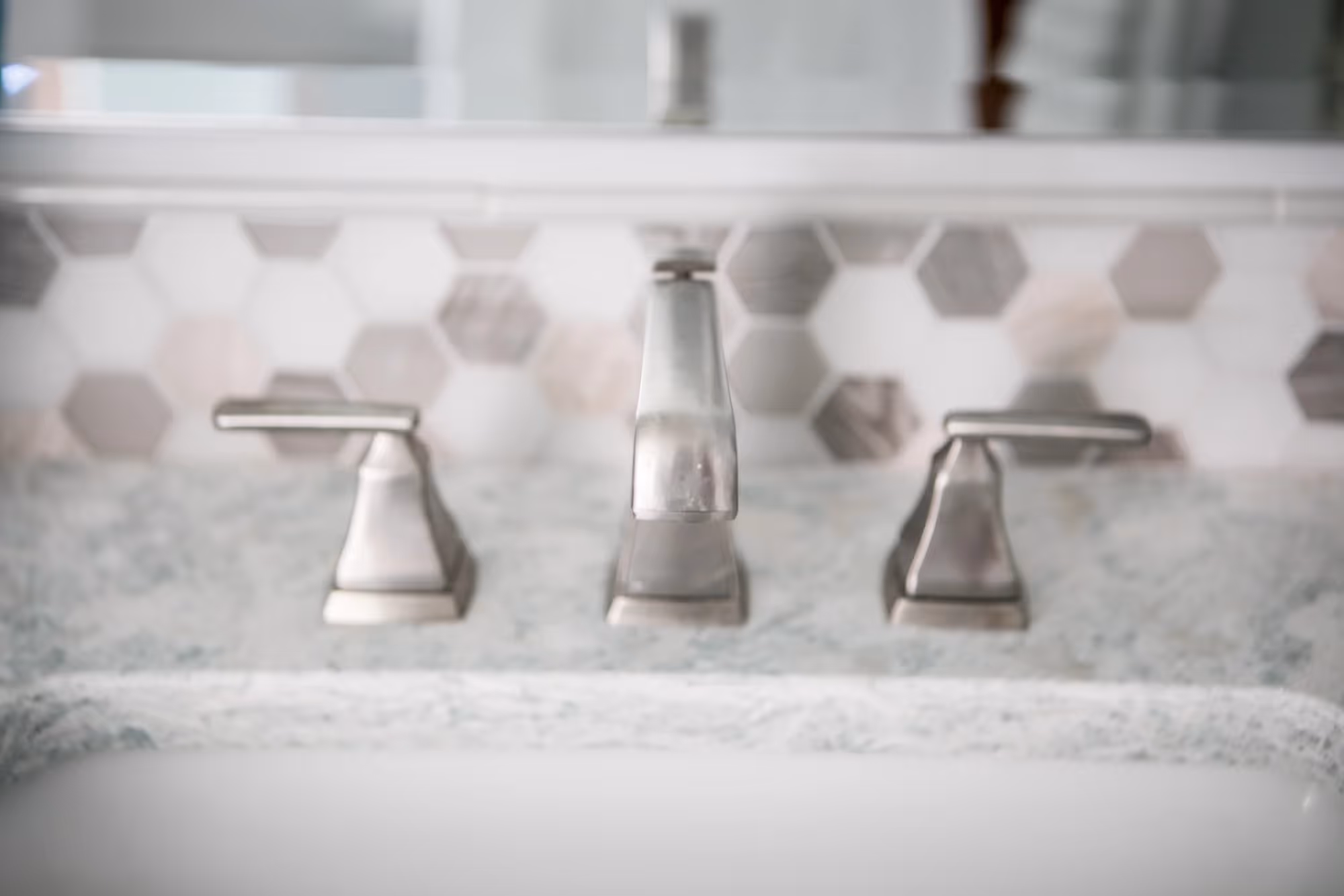 Close-up of bathroom sink faucet and countertop