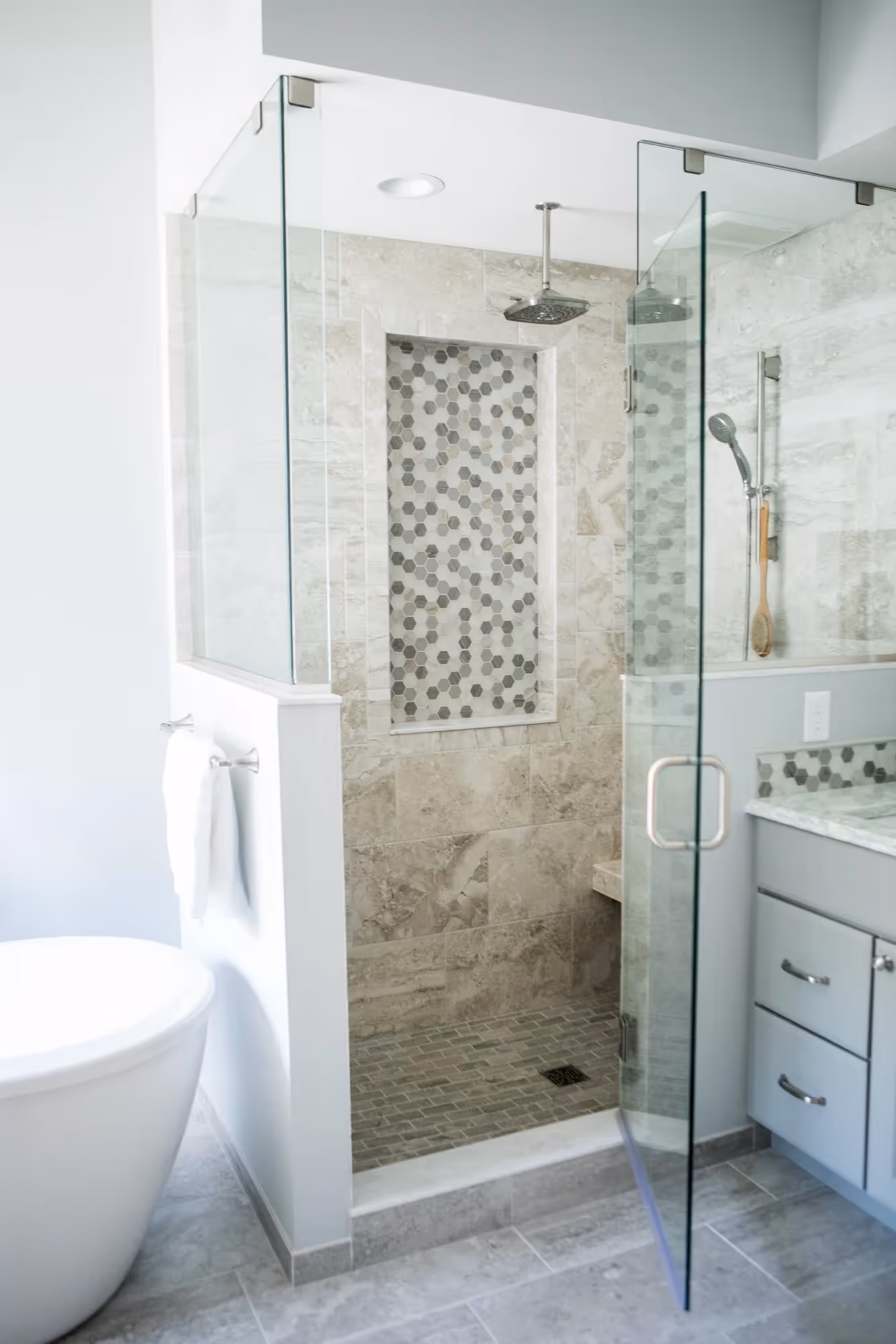 Modern bathroom with a glass shower enclosure and neutral tiles.