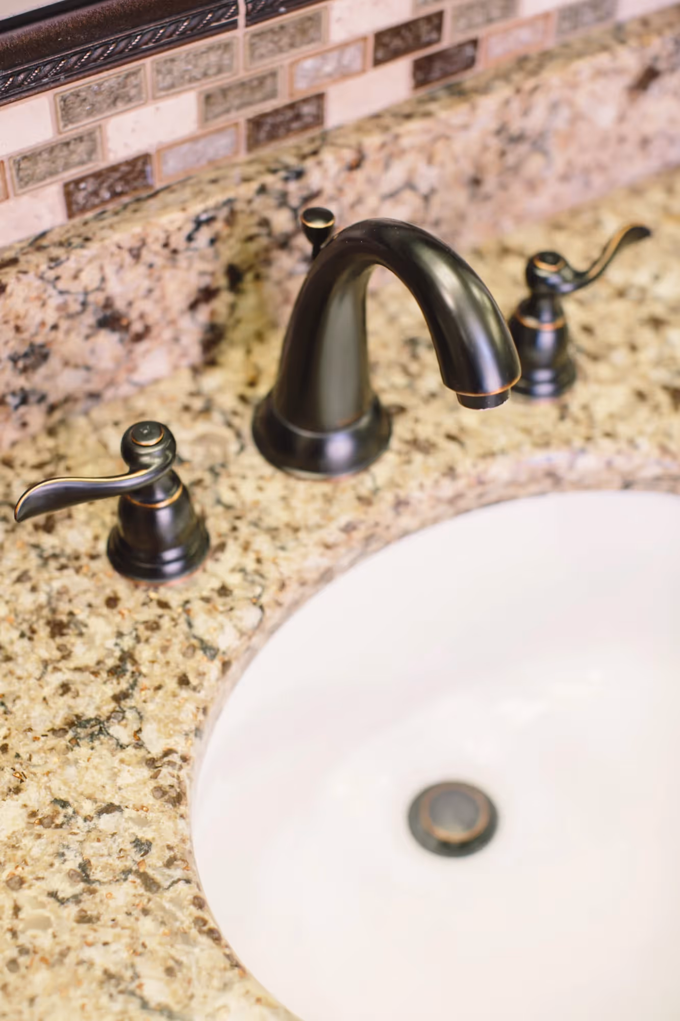 Round sink set in speckled stone countertop