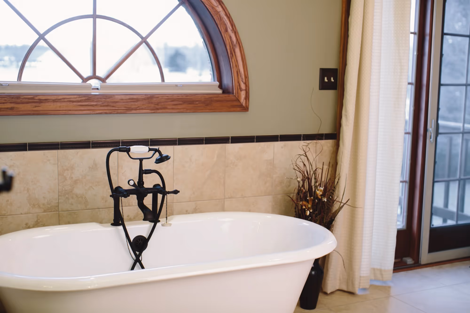 Bathtub with arched window and pendant light