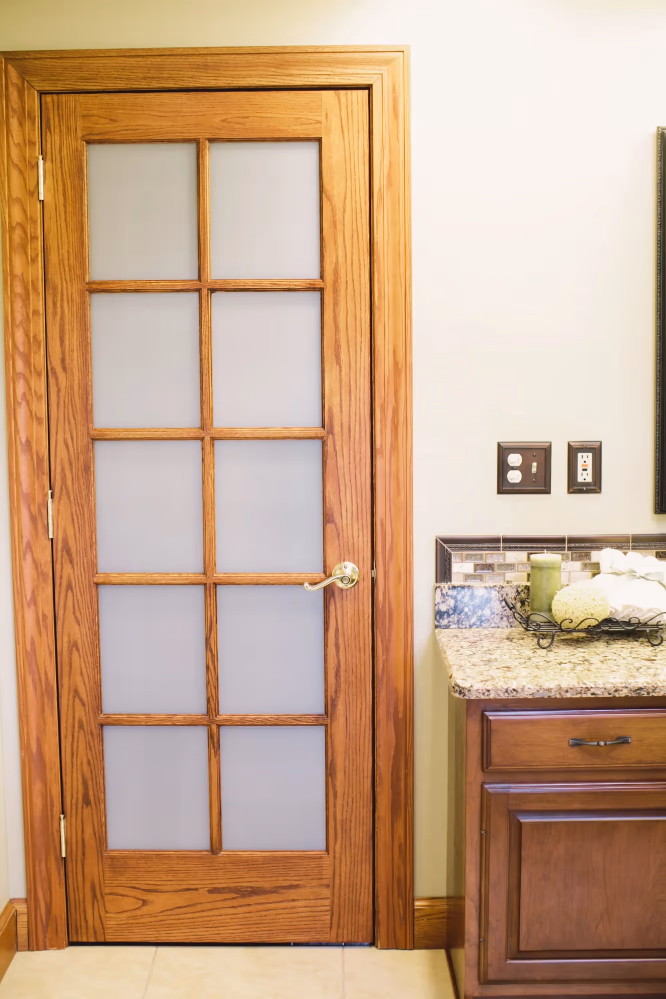 Bathroom entry with wooden door and tiled floor