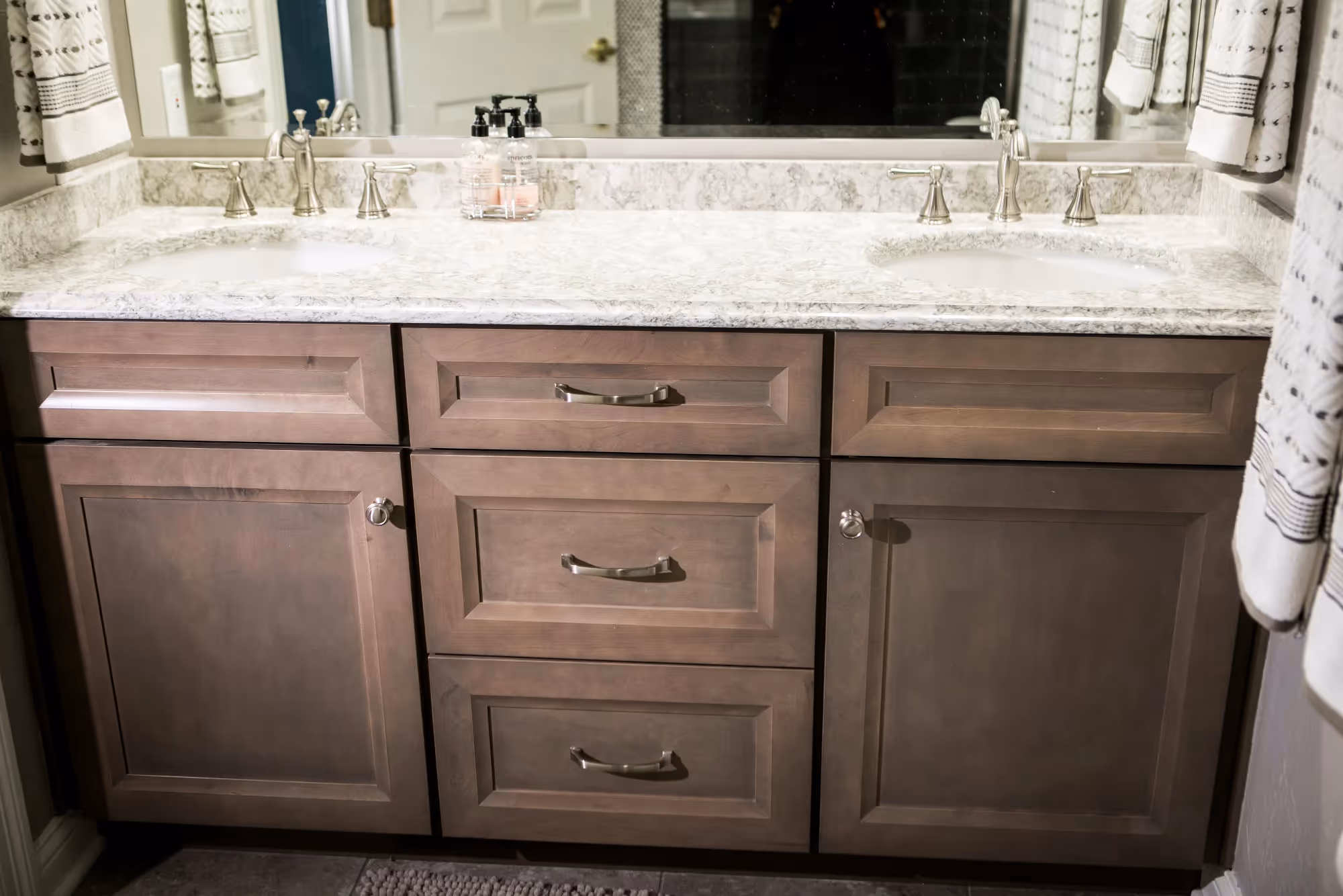 Wooden bathroom vanity with granite countertop and sink.