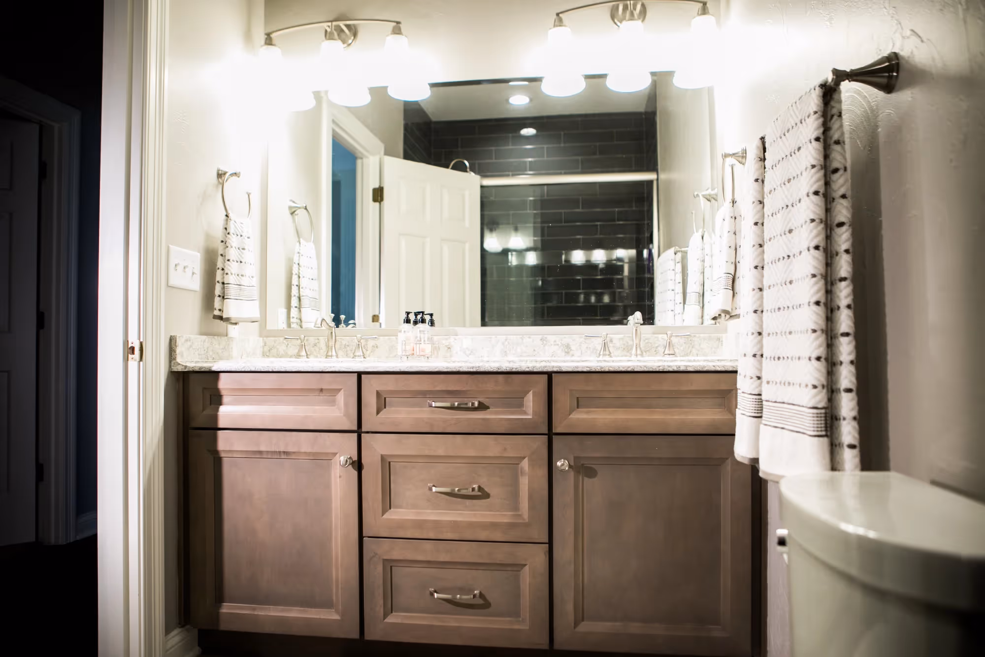 Bathroom with wooden vanity and large mirror.