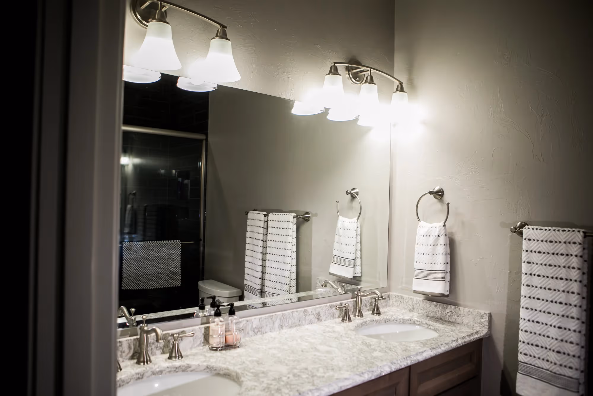 Bathroom vanity with two sinks and decorative lighting.