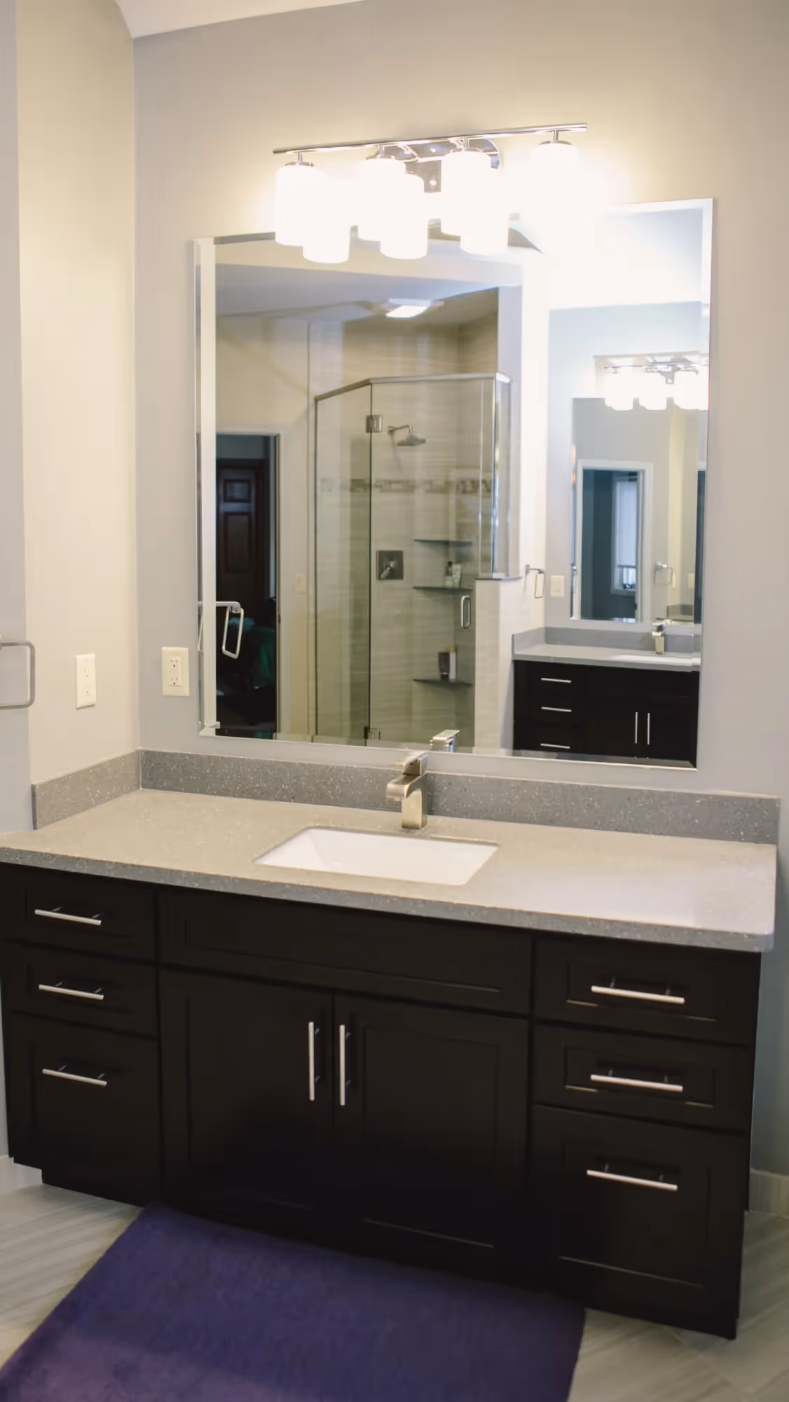 Bathroom vanity with double sinks and dark cabinetry.