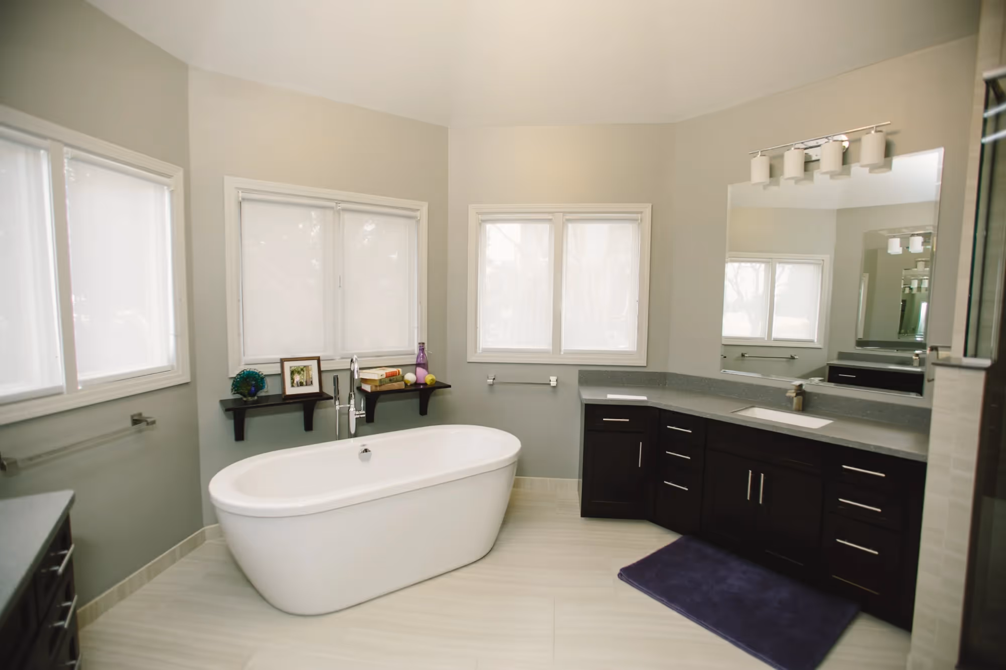 Modern bathroom with bathtub, double sinks, and large mirrors.