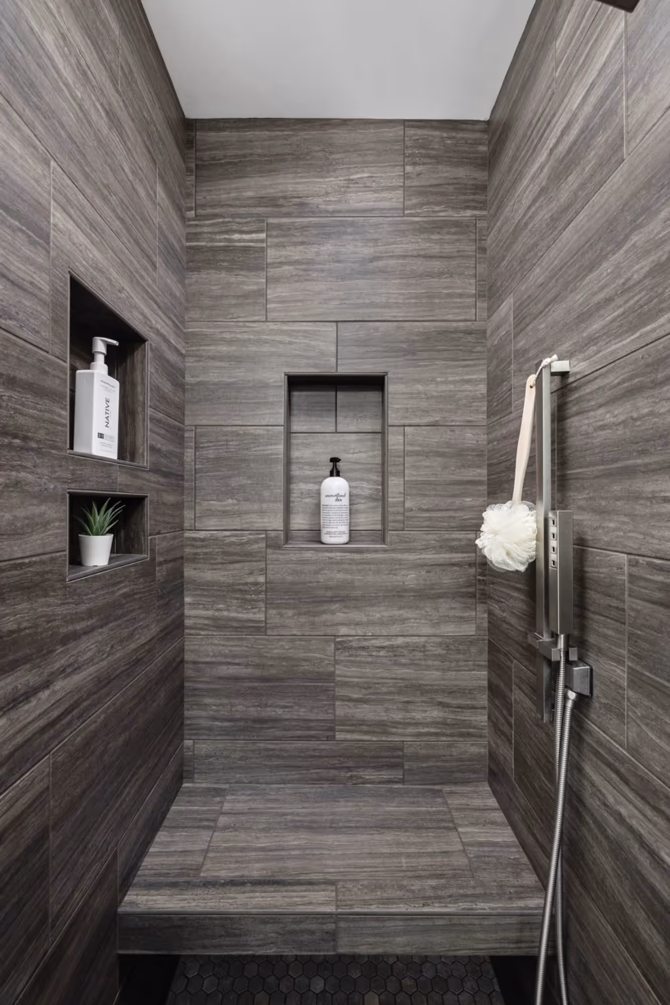 Walk-in shower with gray tile walls