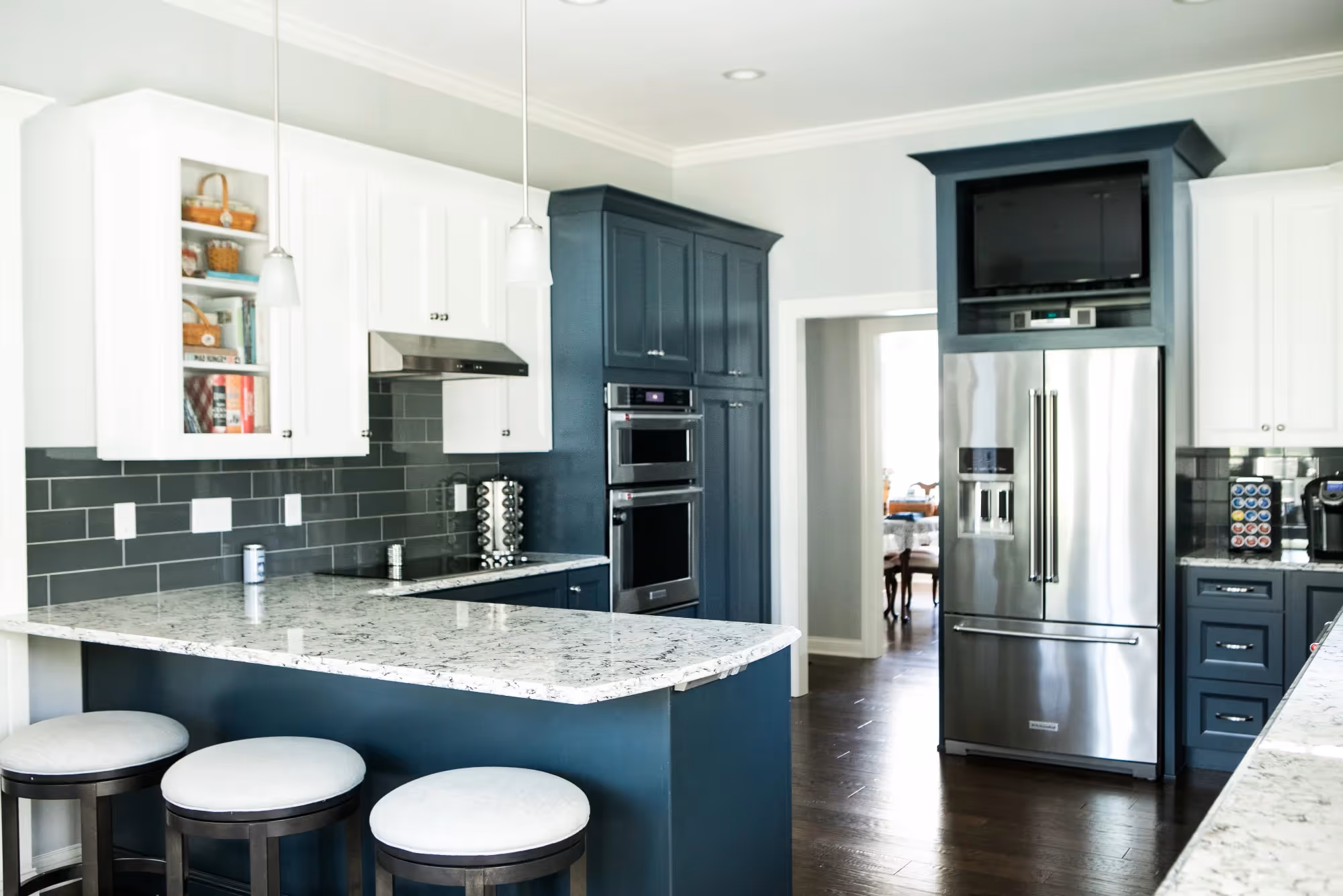 Spacious kitchen with dark wood floors, large island, and modern appliances.