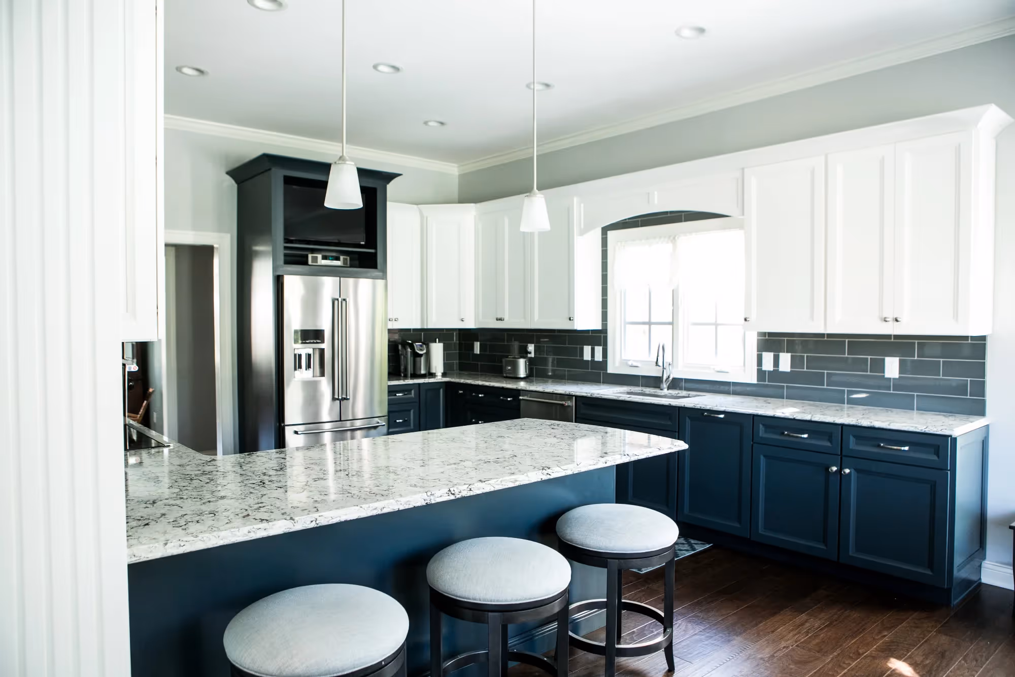 Contemporary kitchen with gray cabinets and island with bar stools.