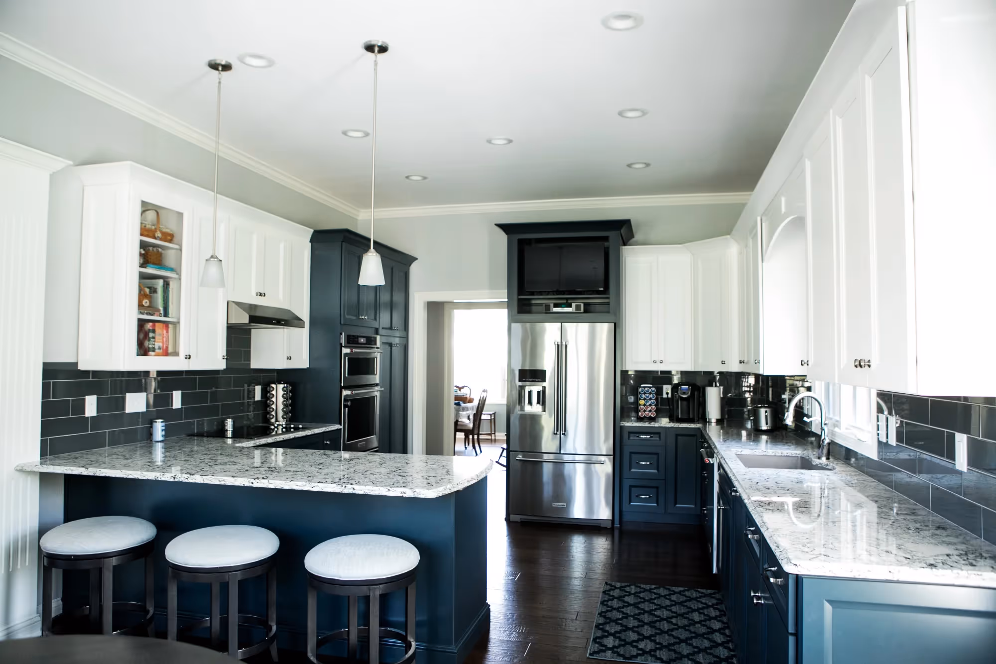 Spacious kitchen with white walls and dark cabinetry.