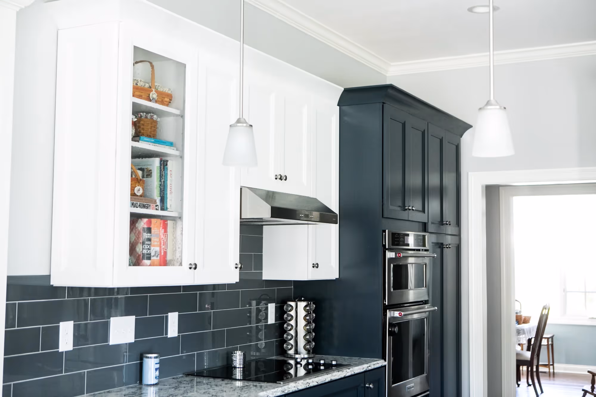 Modern kitchen with built-in shelves and dark blue cabinets.