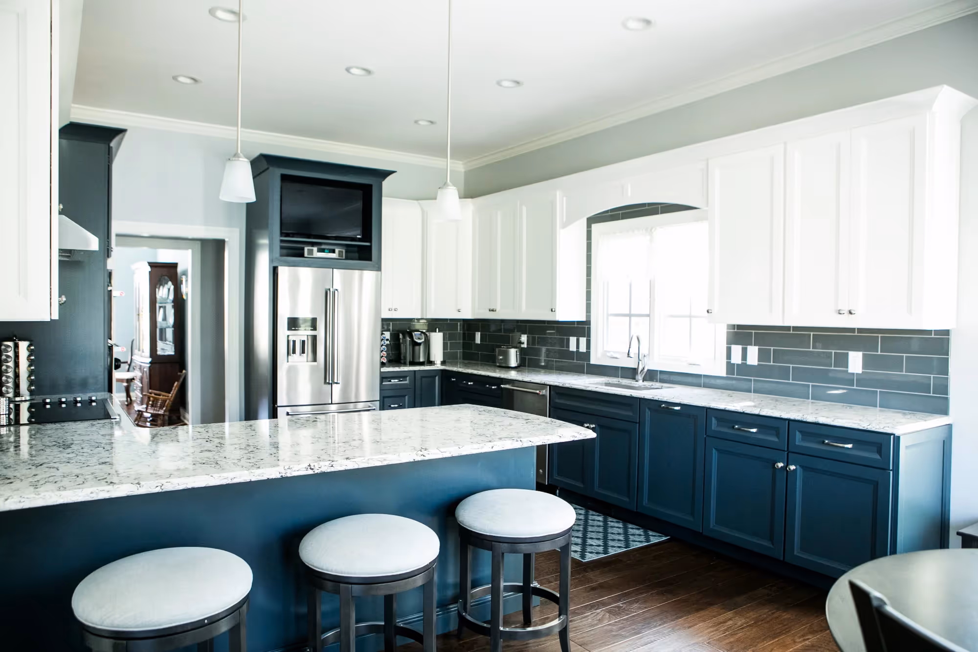 Modern kitchen with gray cabinets, white countertops, and stainless steel appliances.