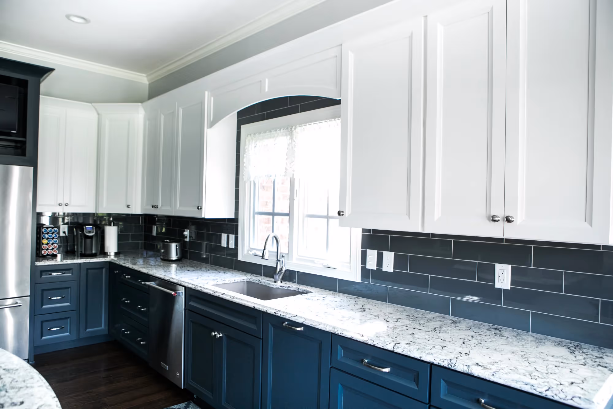 Bright kitchen with white cabinets and dark countertops