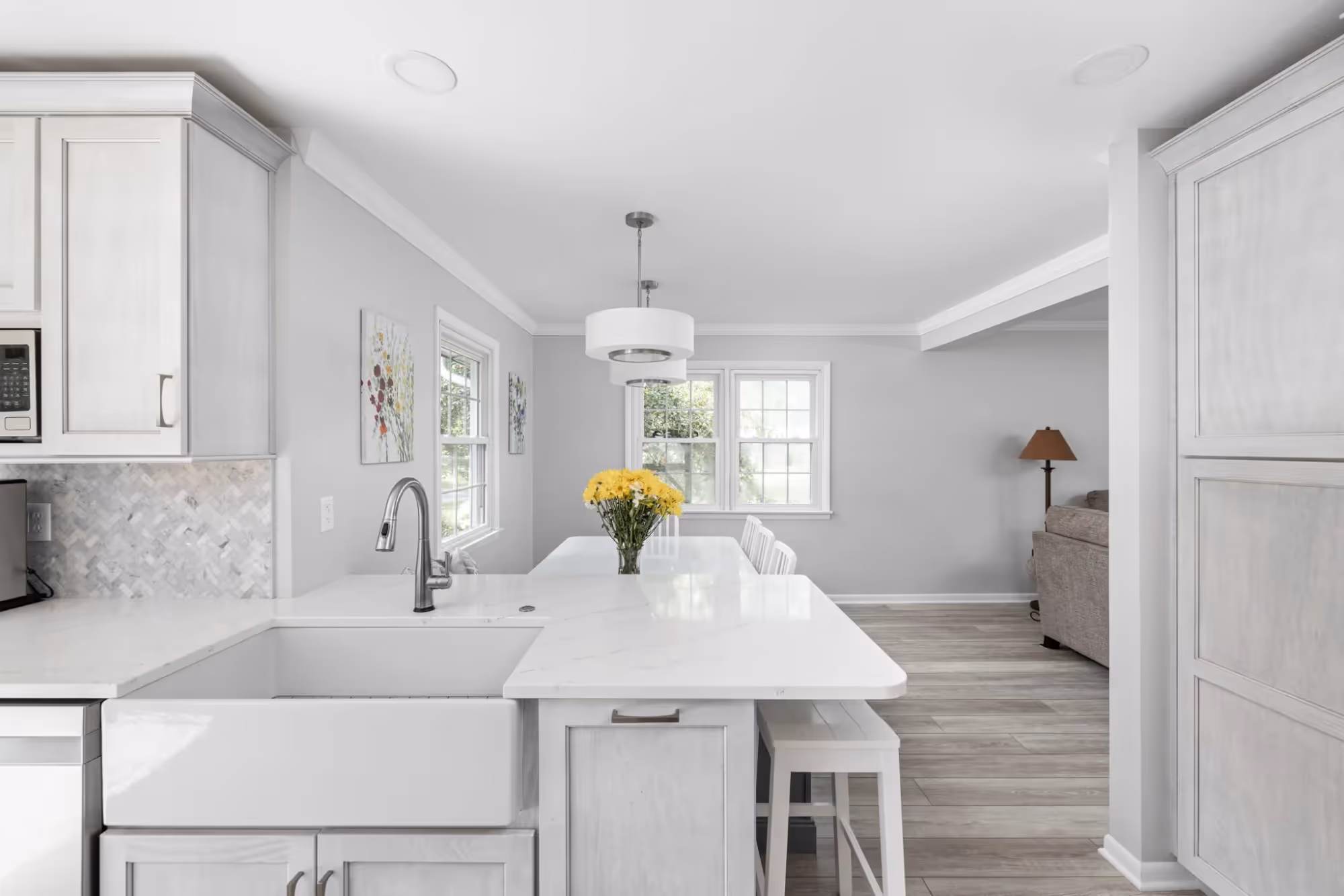 Modern kitchen with white cabinets and pendant lights above island.