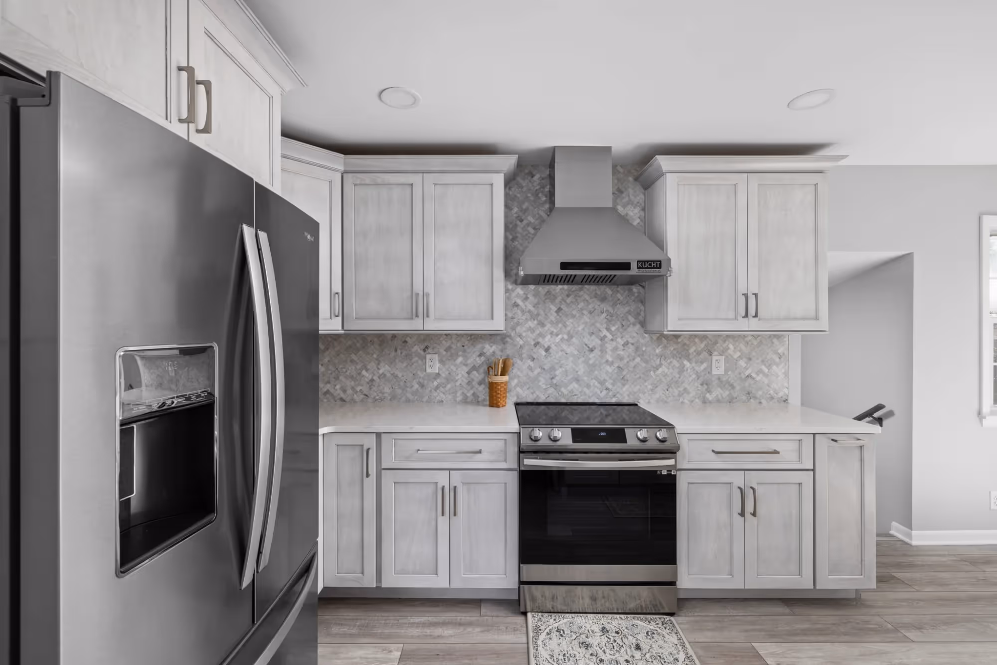 Spacious kitchen with stainless steel appliances and white cabinetry.