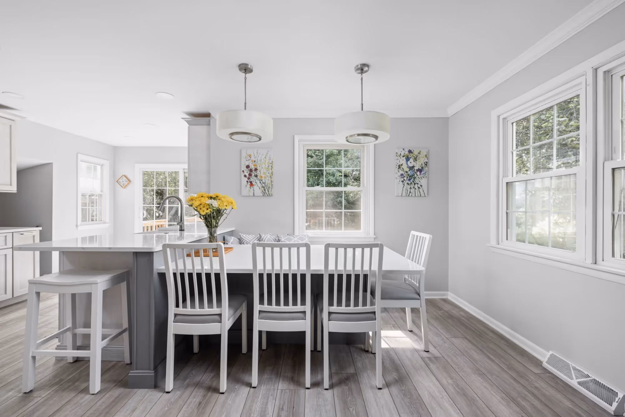 White kitchen with pendant lights and high stools