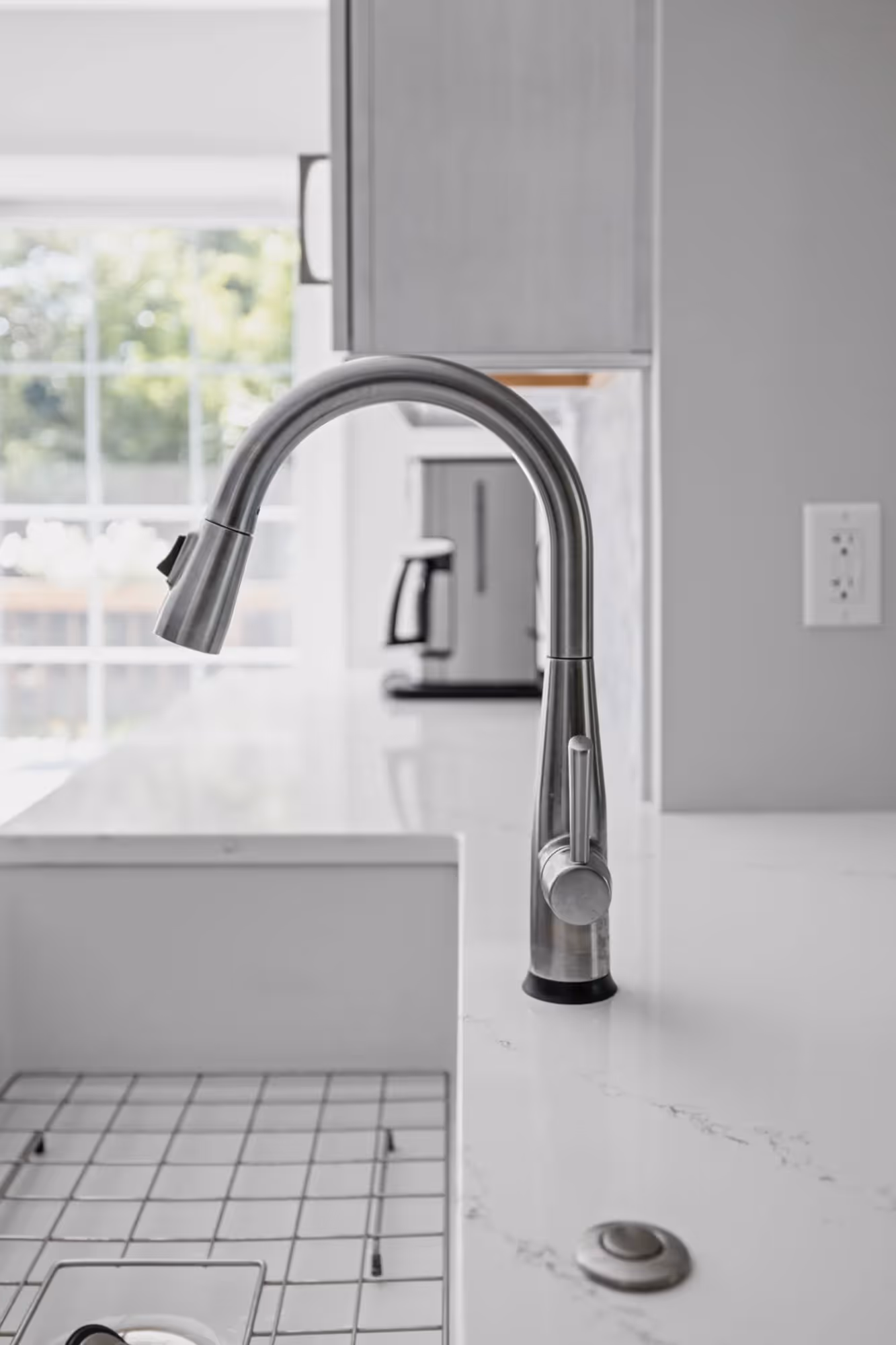 Chrome kitchen faucet over white sink.
