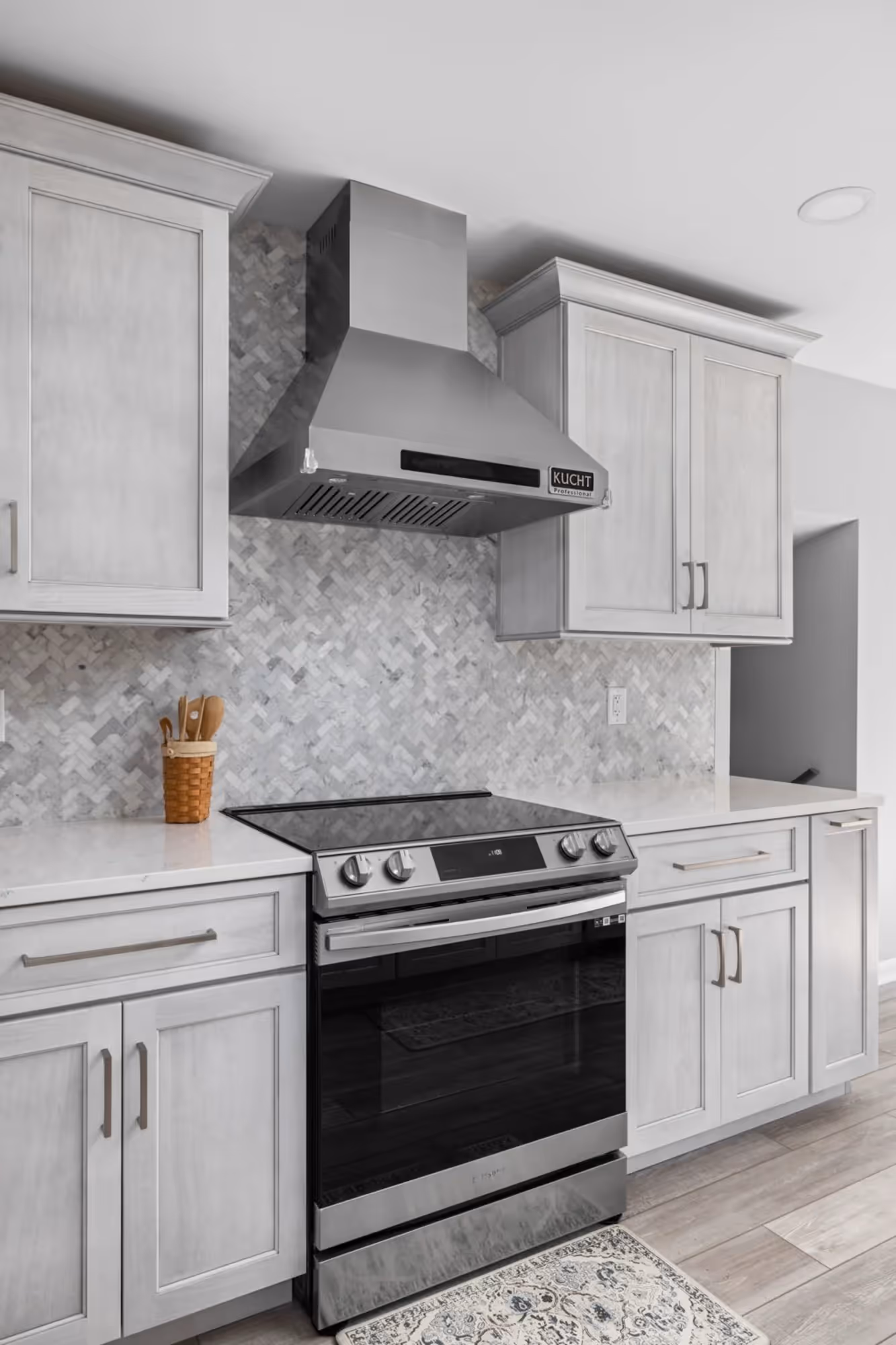 Compact kitchen with white cabinets, subway tile backsplash, and Chimney.