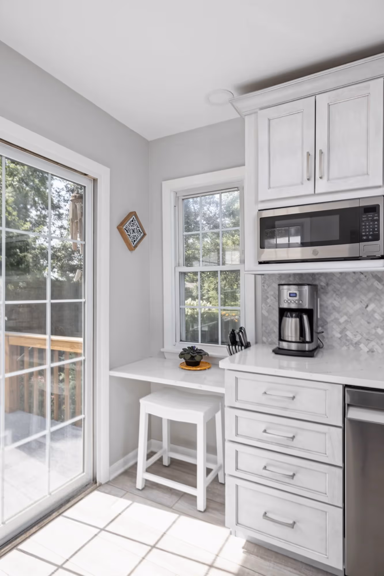 Bright kitchen with stainless steel appliances and white countertops.