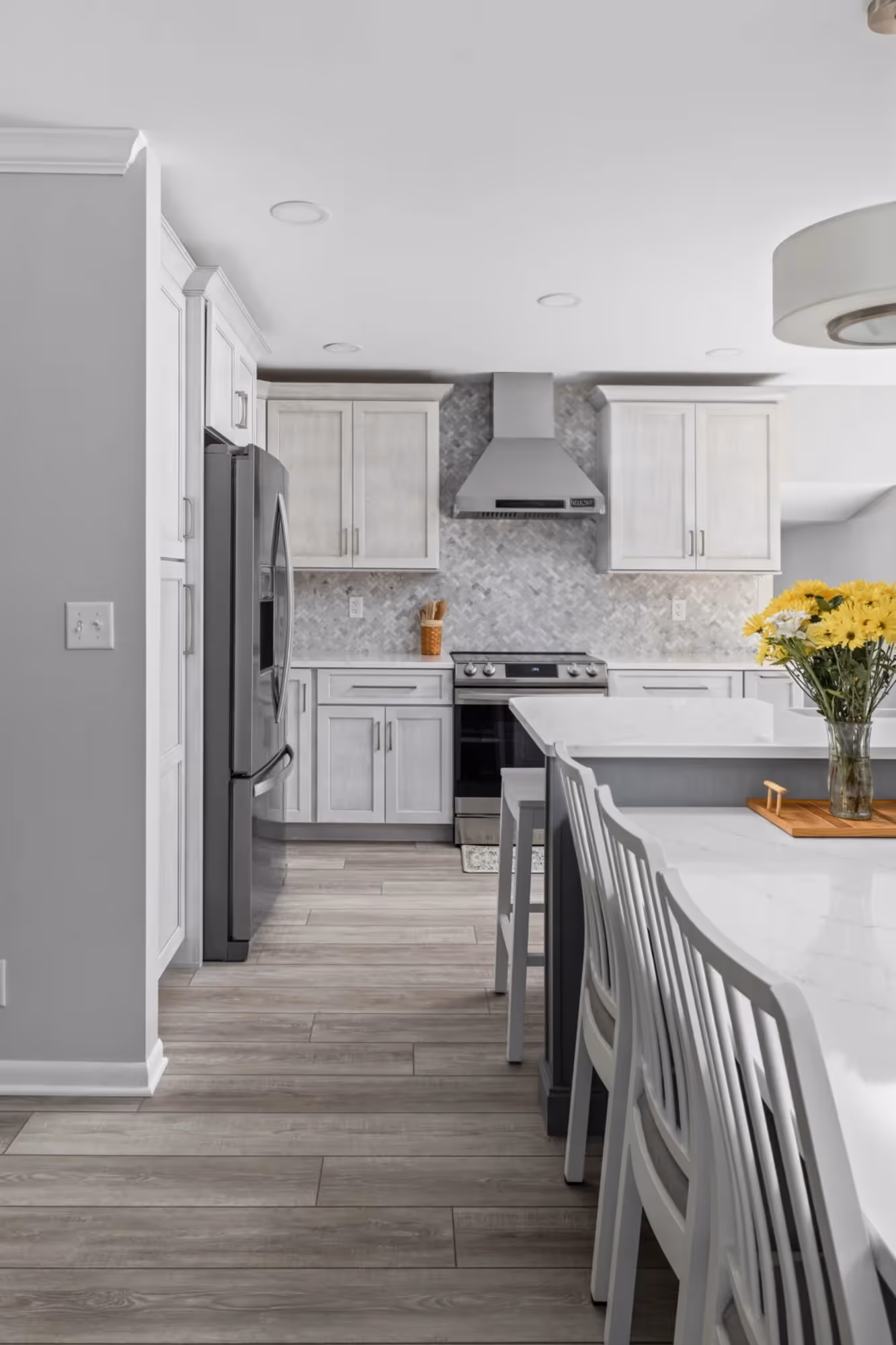 Kitchen island with bar stools and gray cabinets.