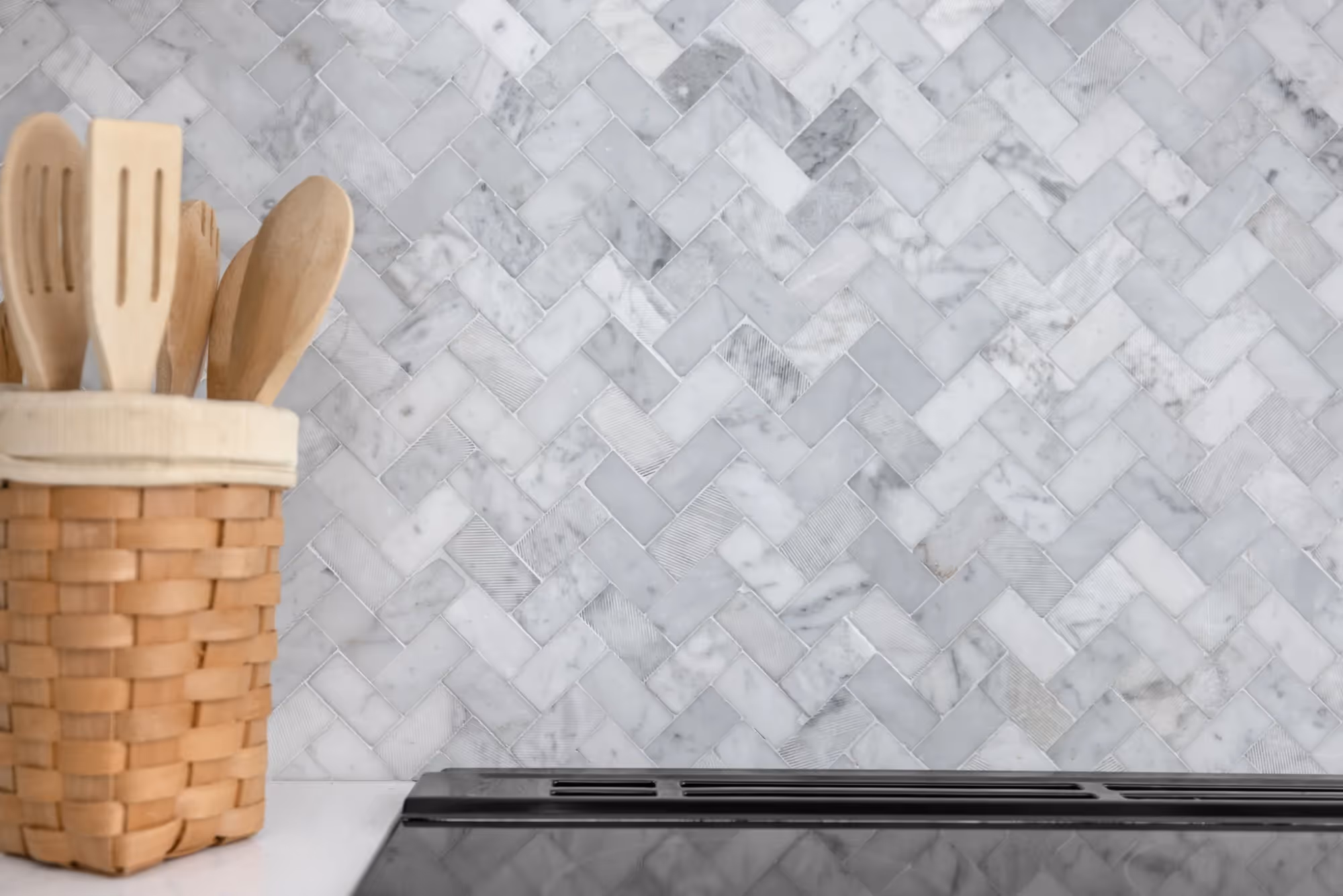 Utensil holder on marble backsplash counter.