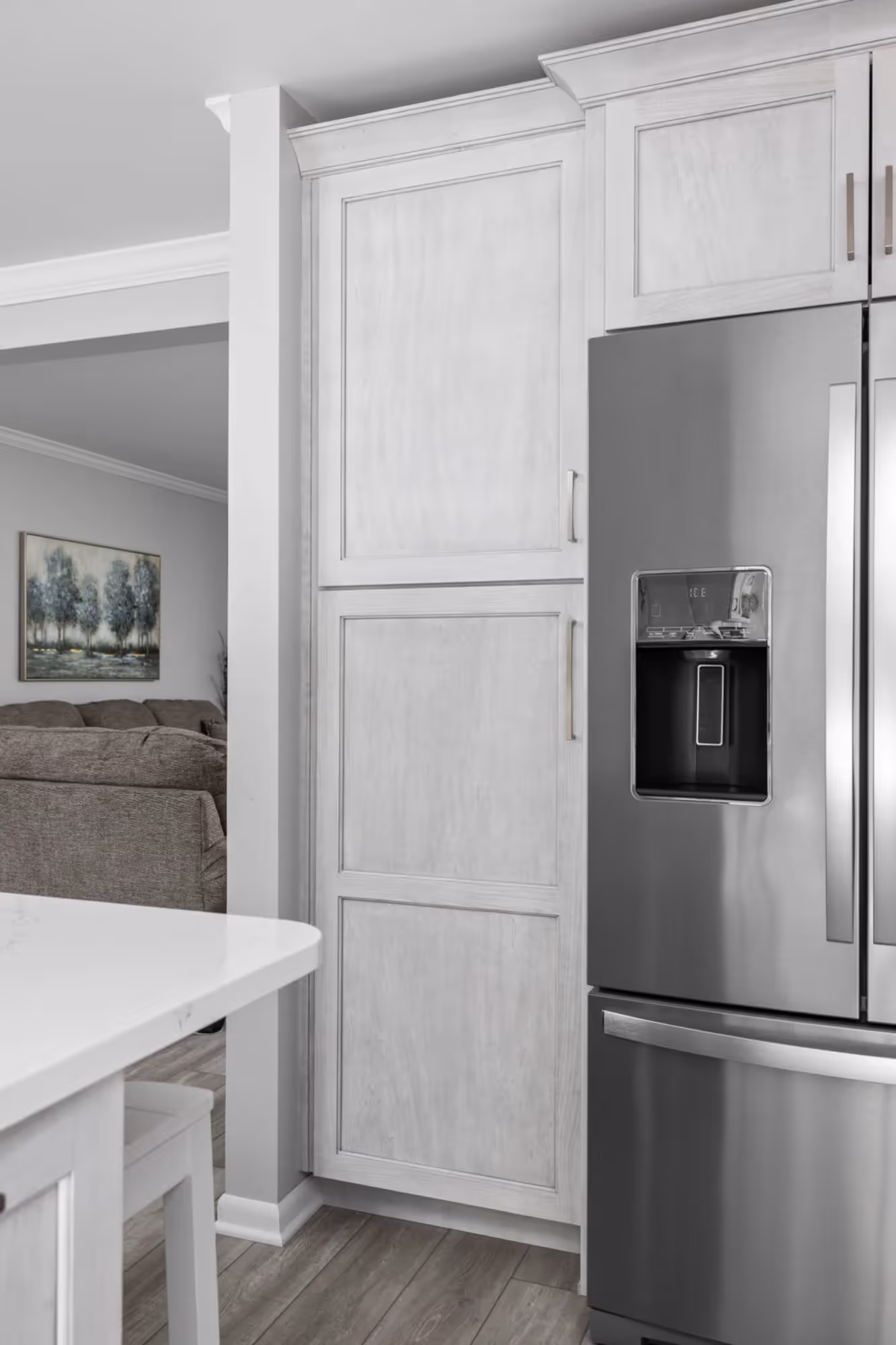 Built-in refrigerator next to white cabinetry.