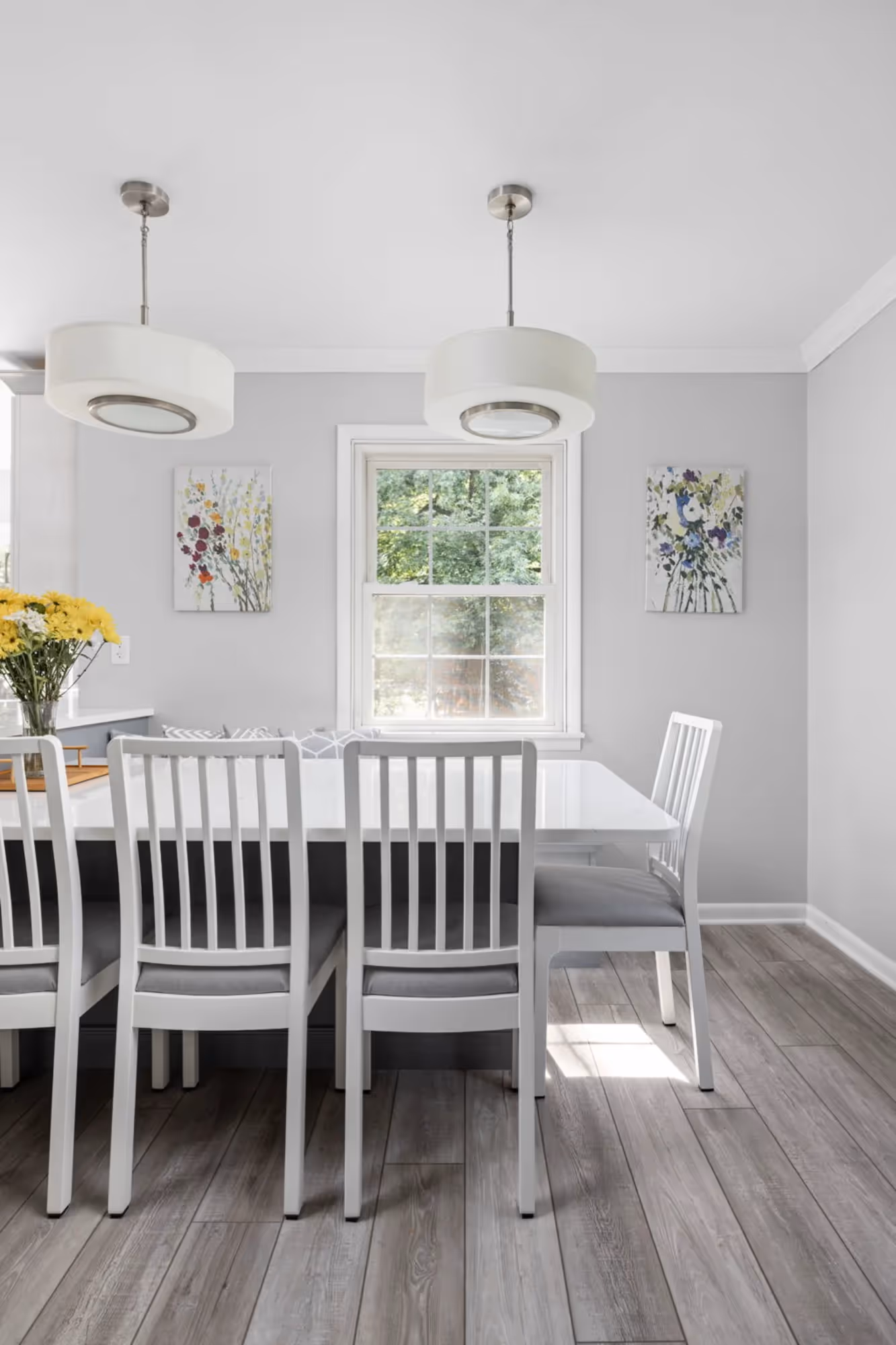 Dining area with white high-back chairs and light wood flooring.