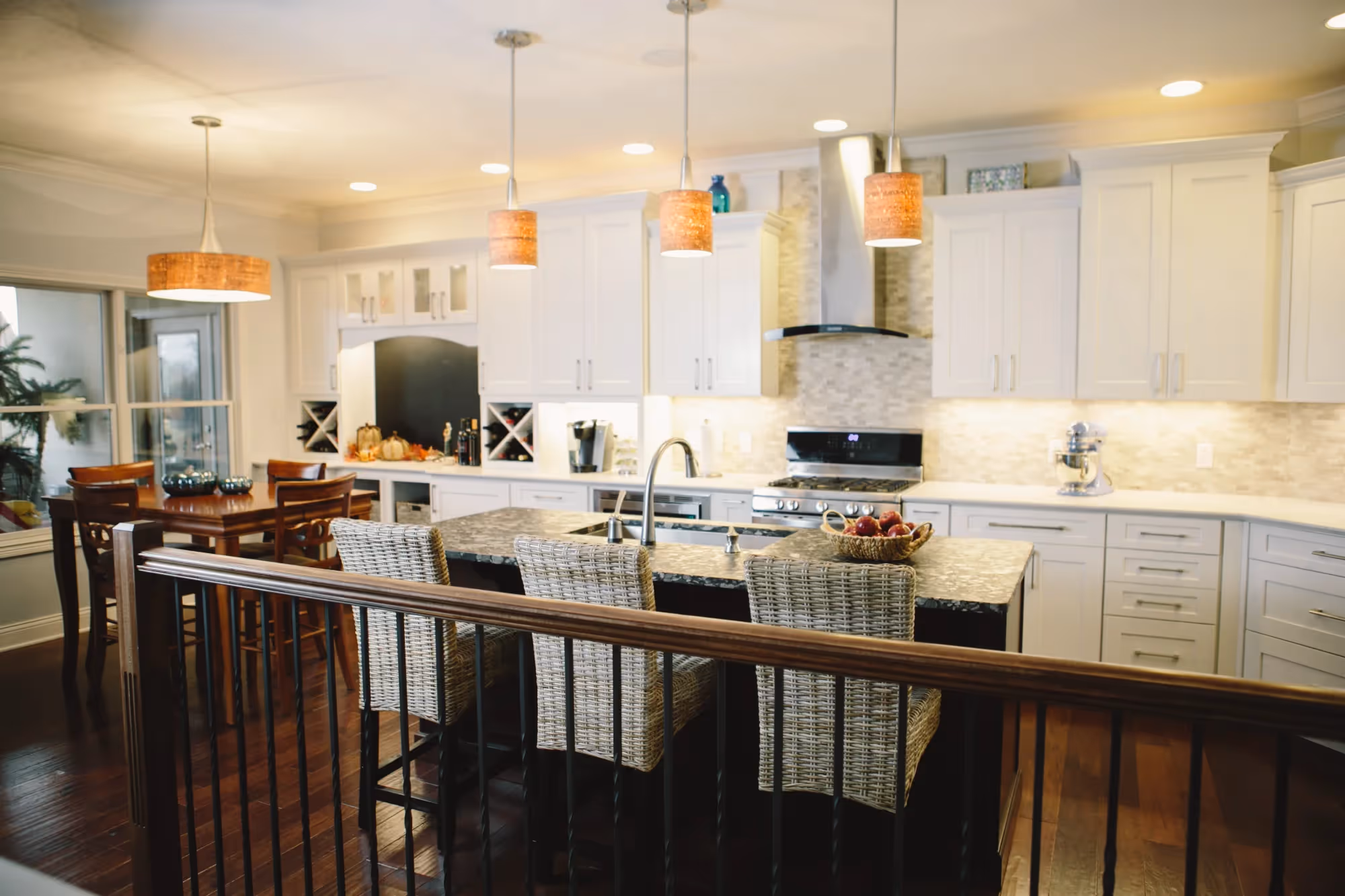Bright kitchen with island and hanging lights.