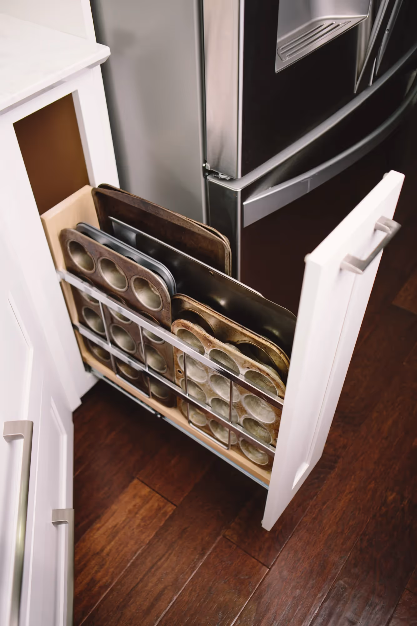 Dishwasher drawer in a kitchen with dark wood flooring.
