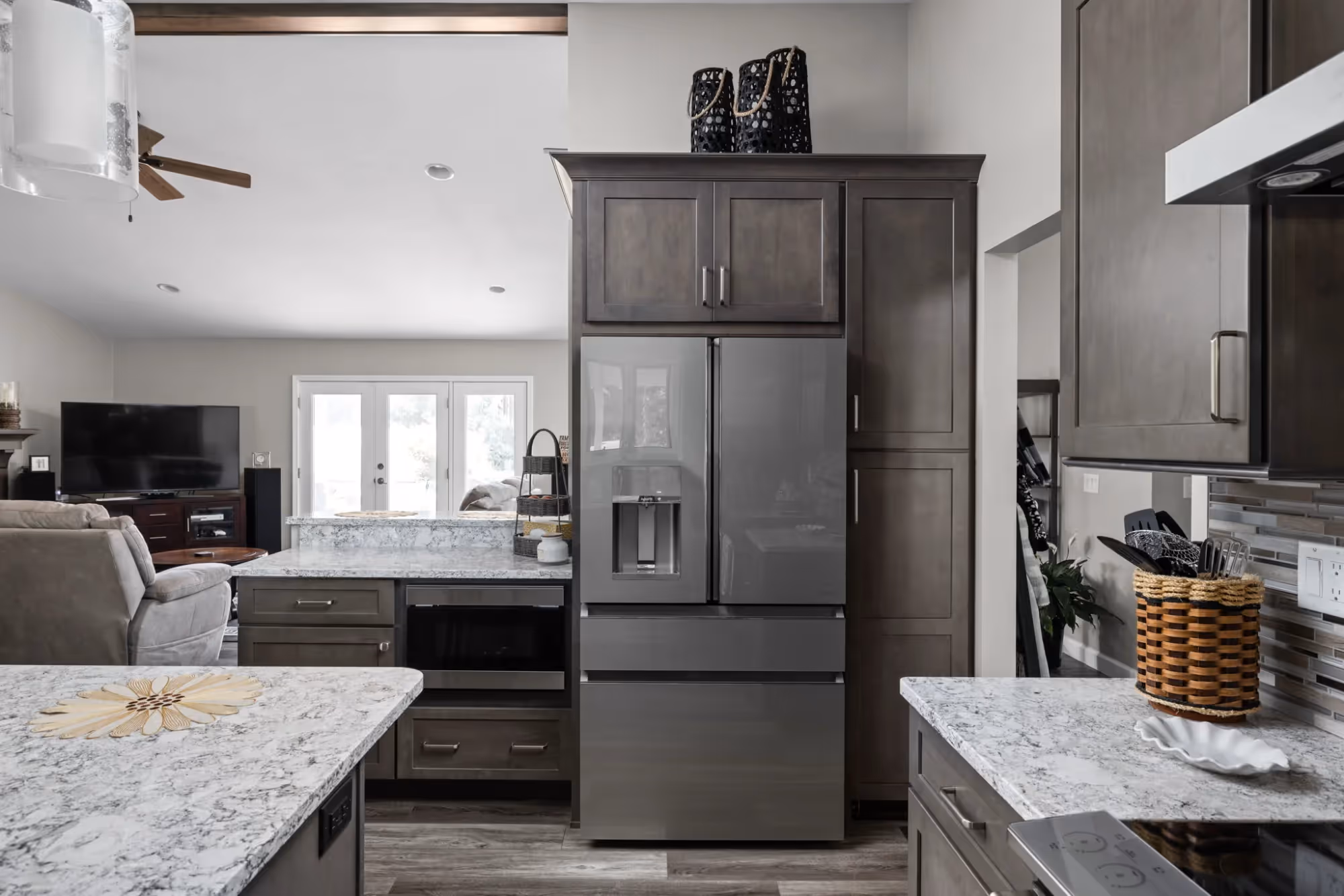 Modern gray kitchen with marble countertops and stainless refrigerator