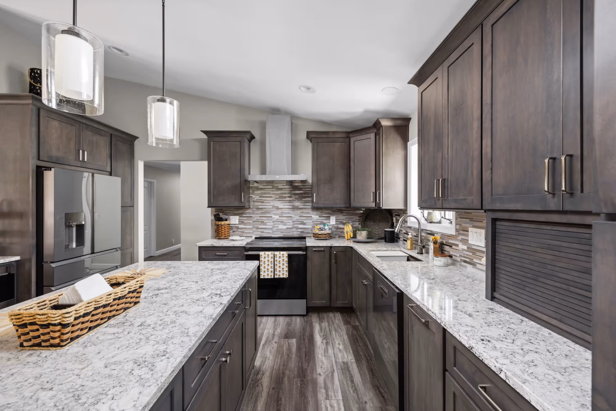 Galley kitchen with dark cabinets and granite counters