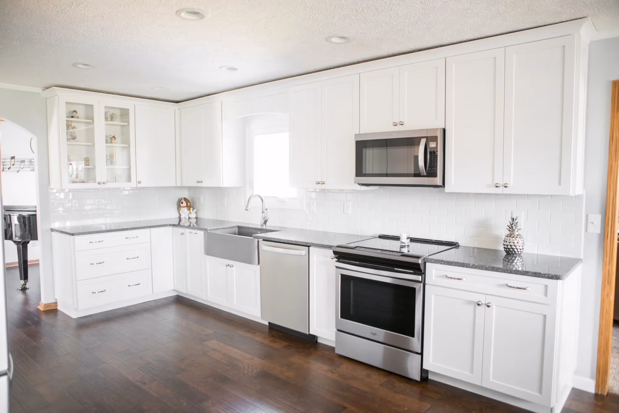 White kitchen with built-in microwave and stove.