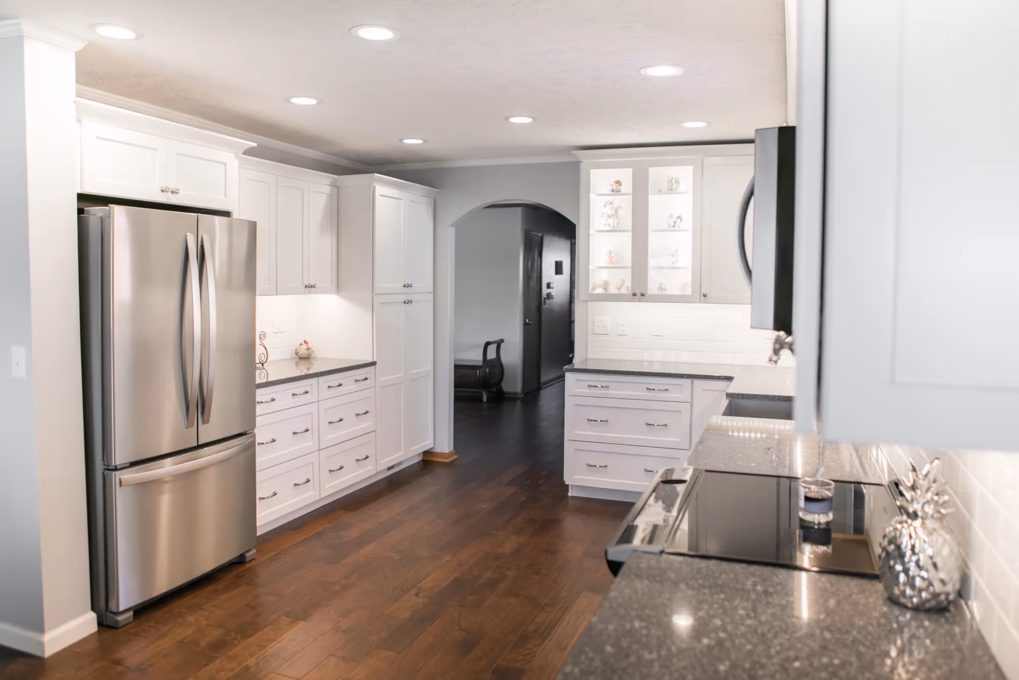 Bright white kitchen with stainless fridge and dark countertops