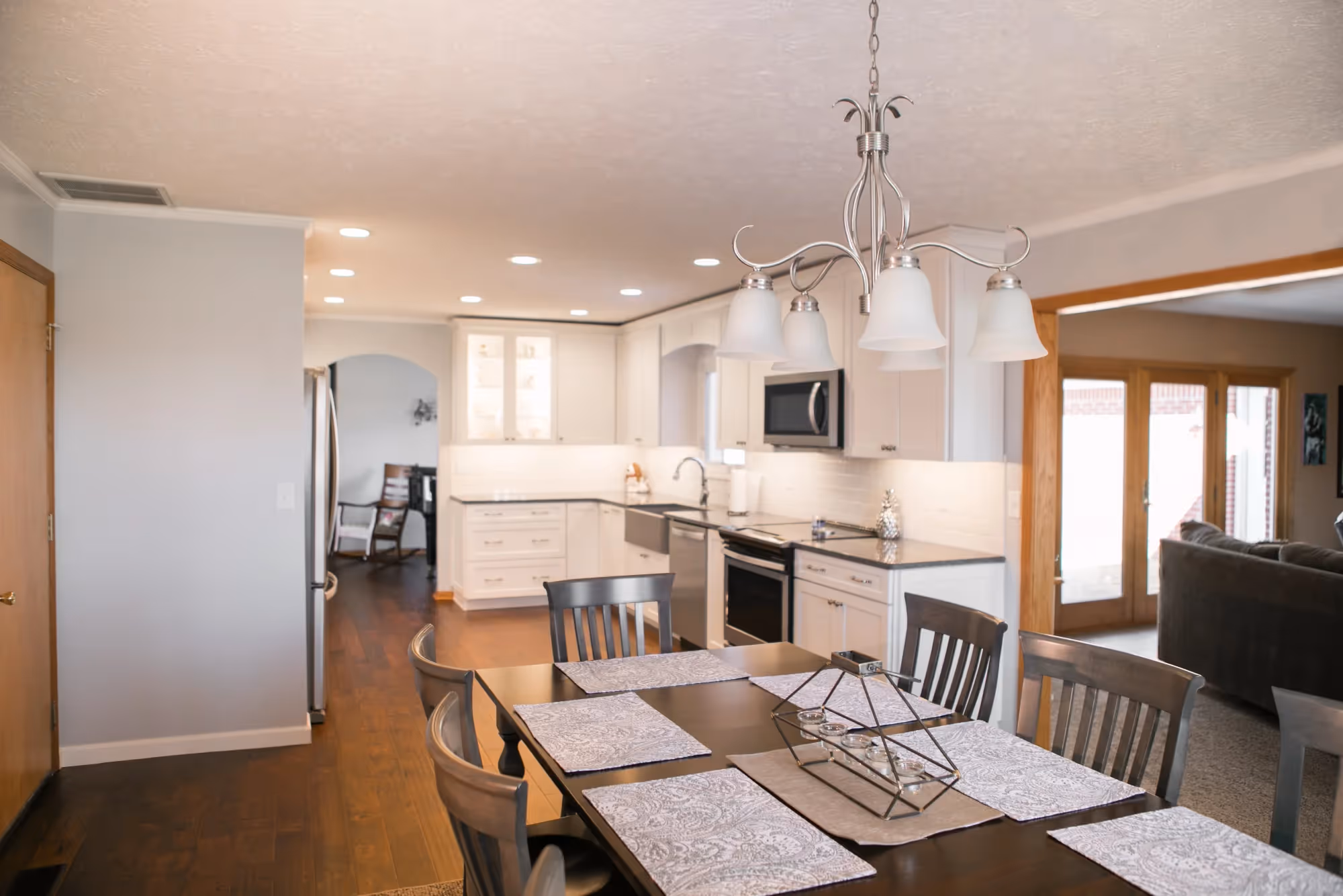 Dining area with a chandelier and table set for six.