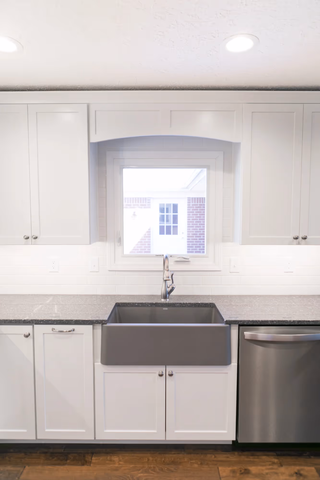 Bright modern kitchen with white cabinets and stainless steel appliances.