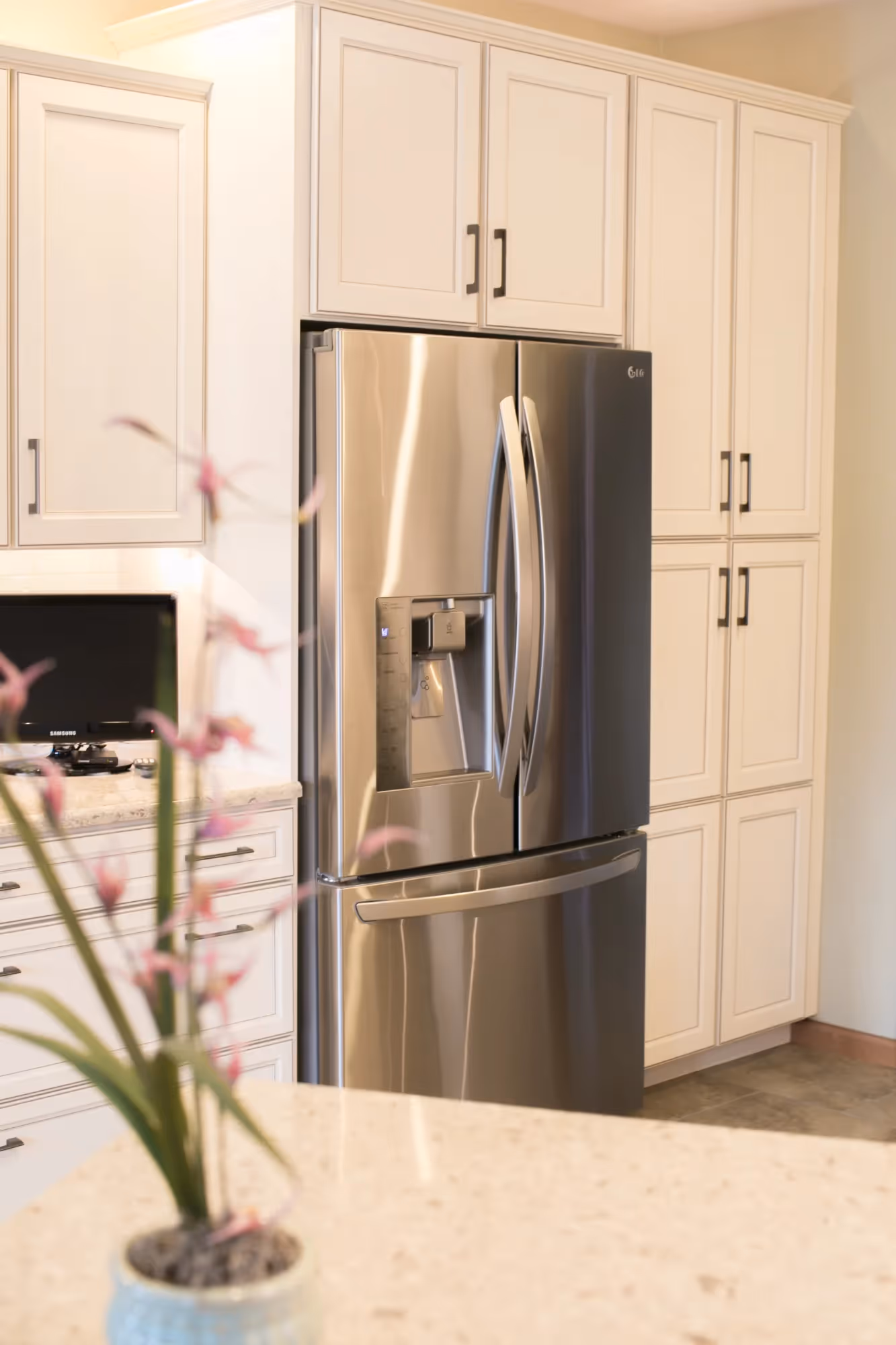 Kitchen with refrigerator, oven, and white cabinetry.
