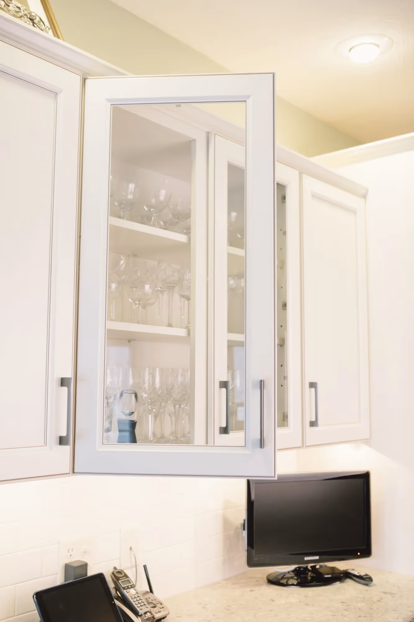 White cabinet doors with glass panels and countertop