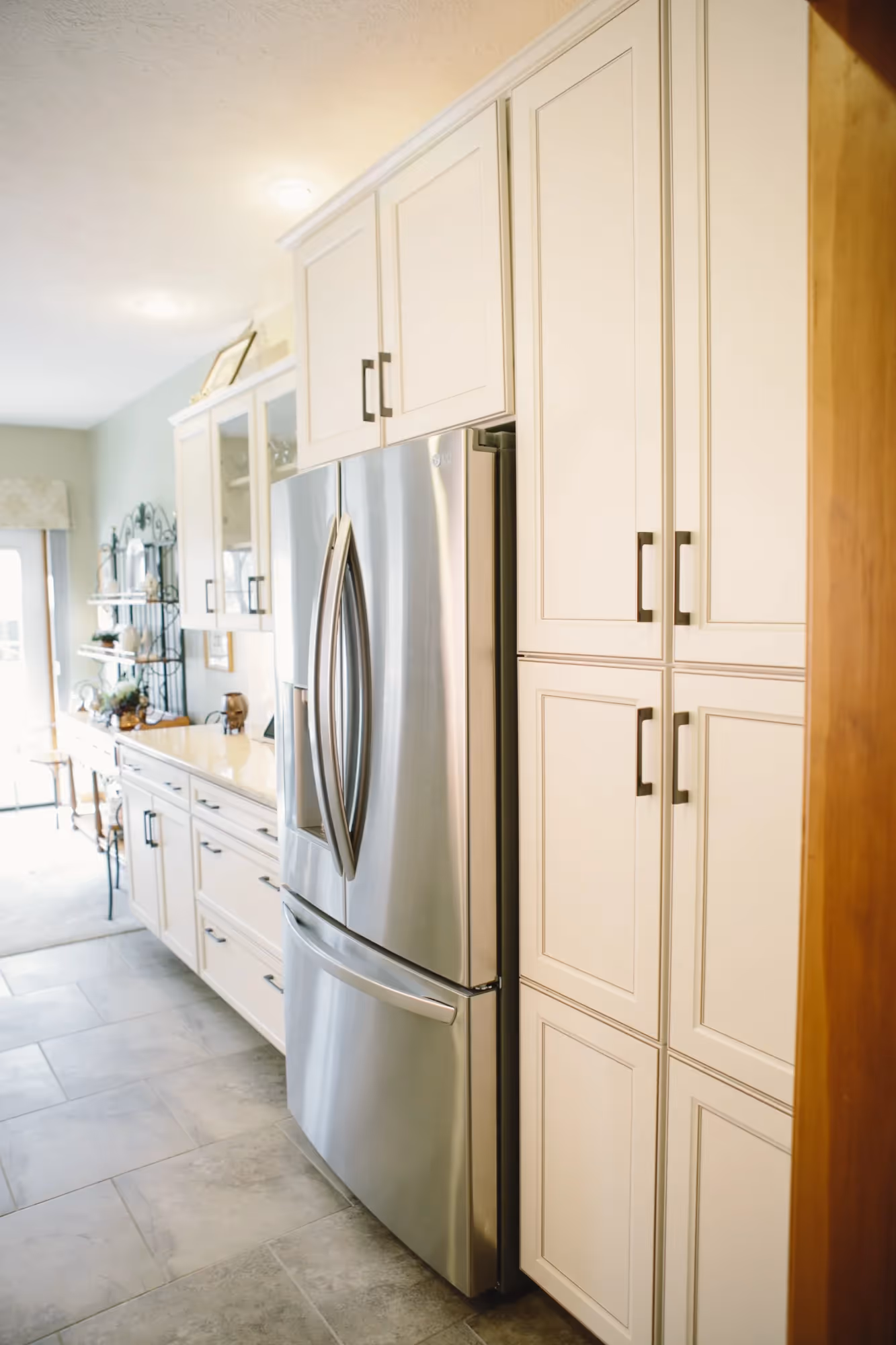 Modern kitchen with white cabinets and stainless steel refrigerator.
