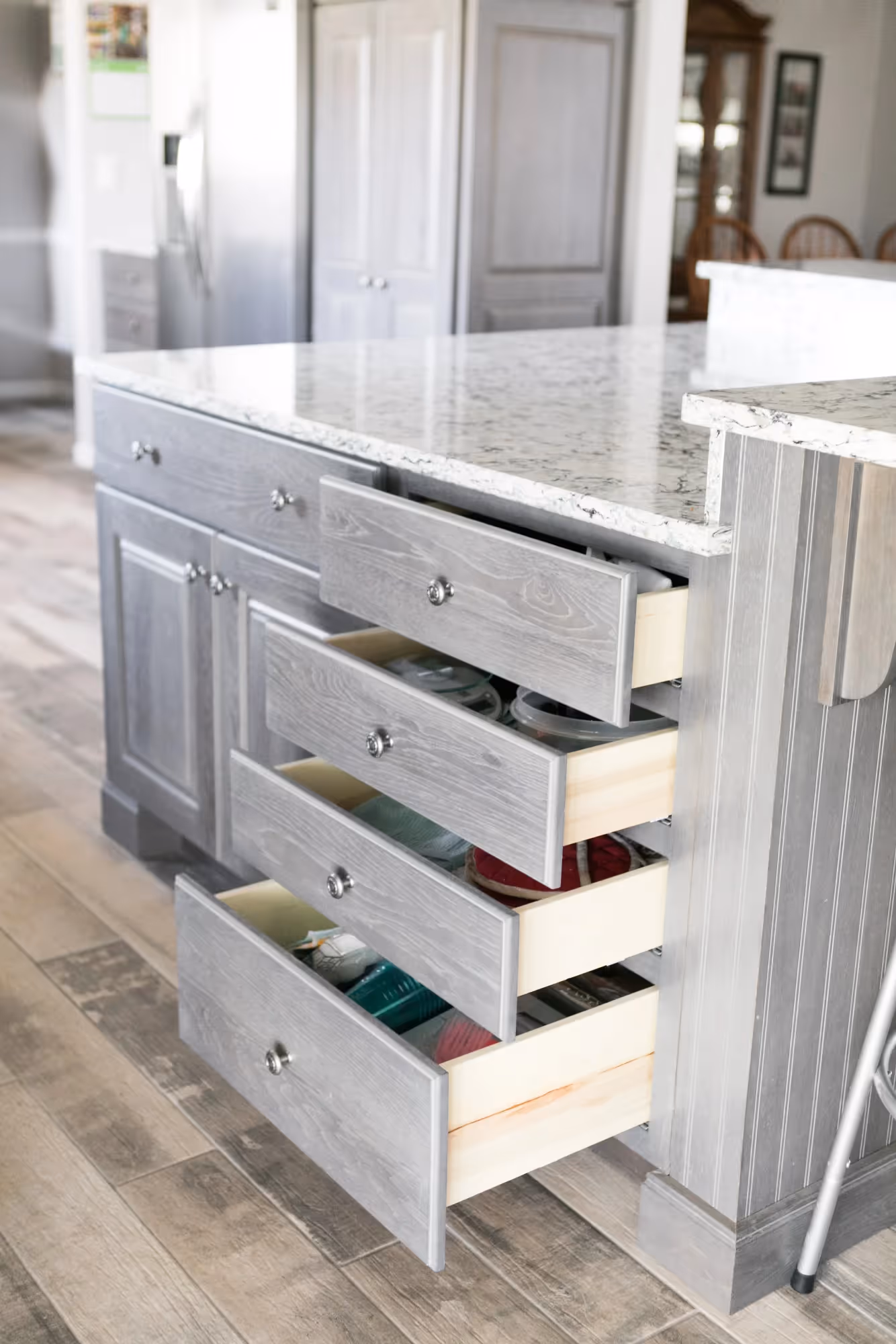 White kitchen with glass-front cabinets and drawers.