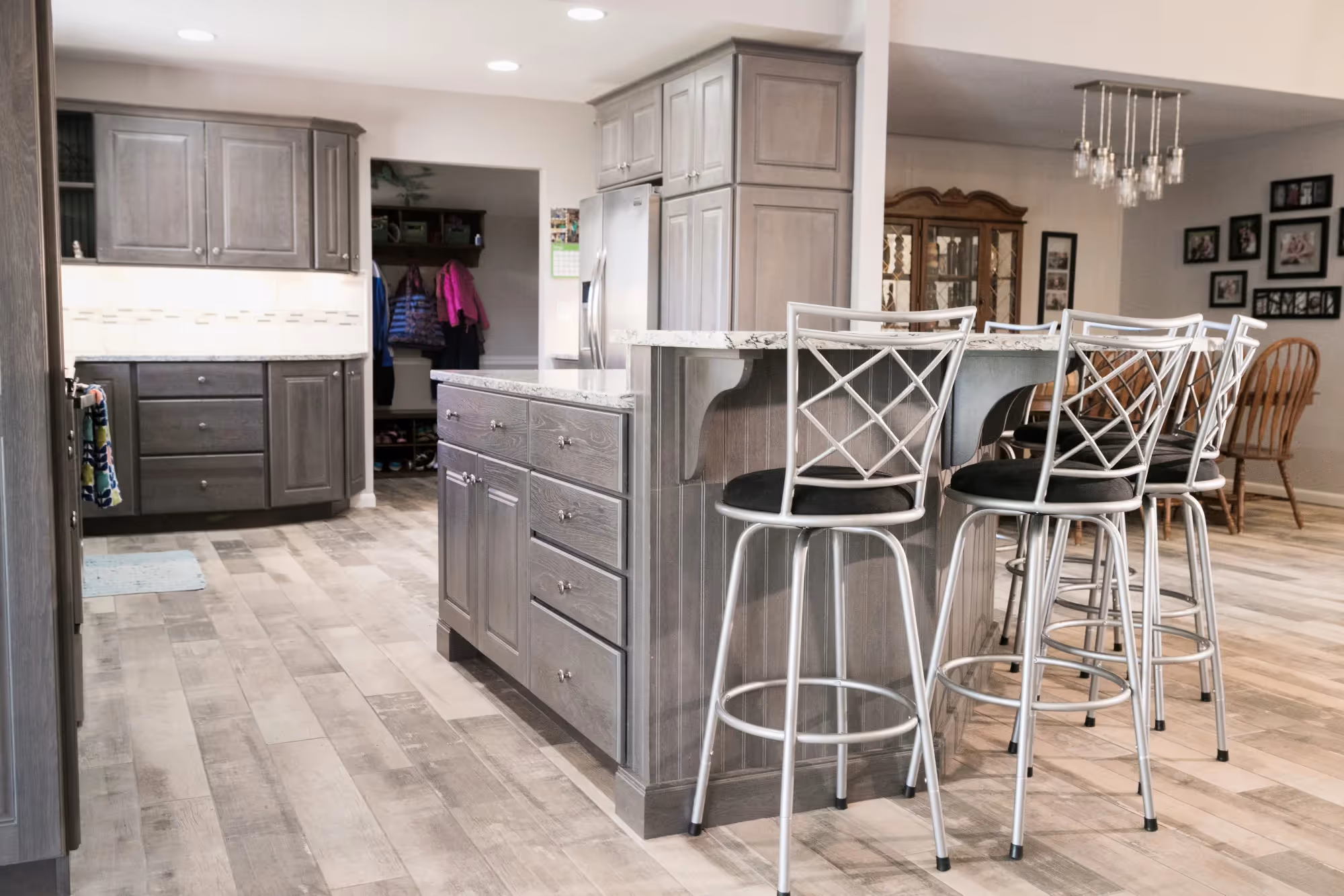 Modern kitchen with gray cabinets, island, and bar stools.