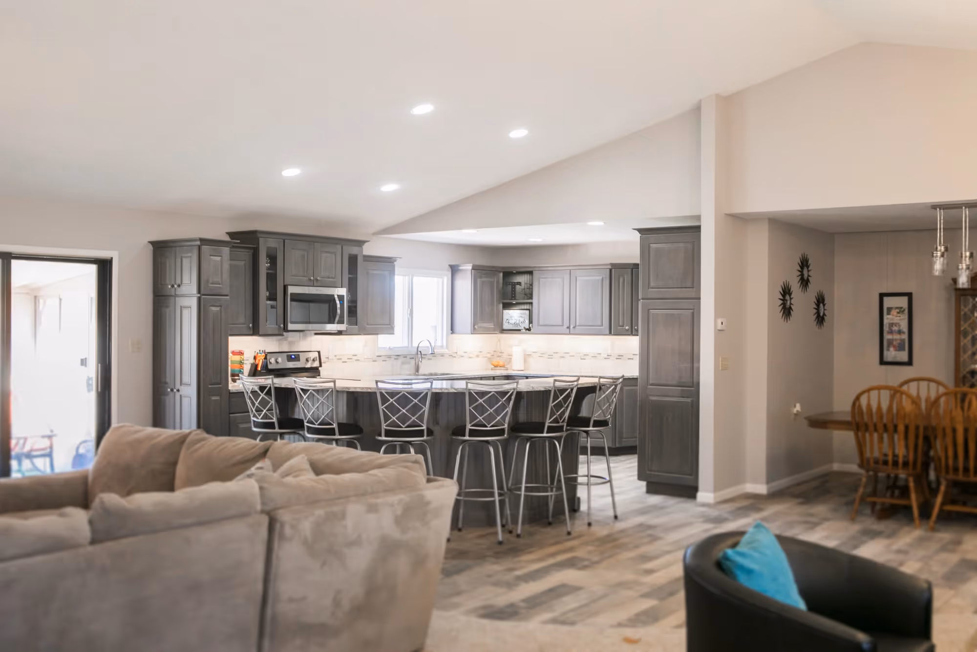 Spacious modern kitchen with island, gray cabinets, and recessed lighting.