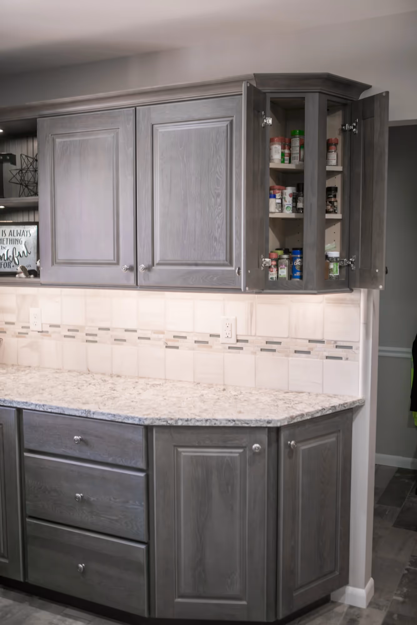 Gray kitchen cabinets with glass-front upper cupboards.