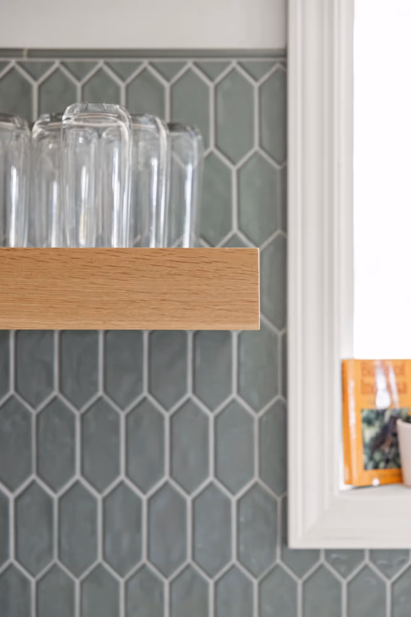 Close-up of teal hexagon tile backsplash with small art