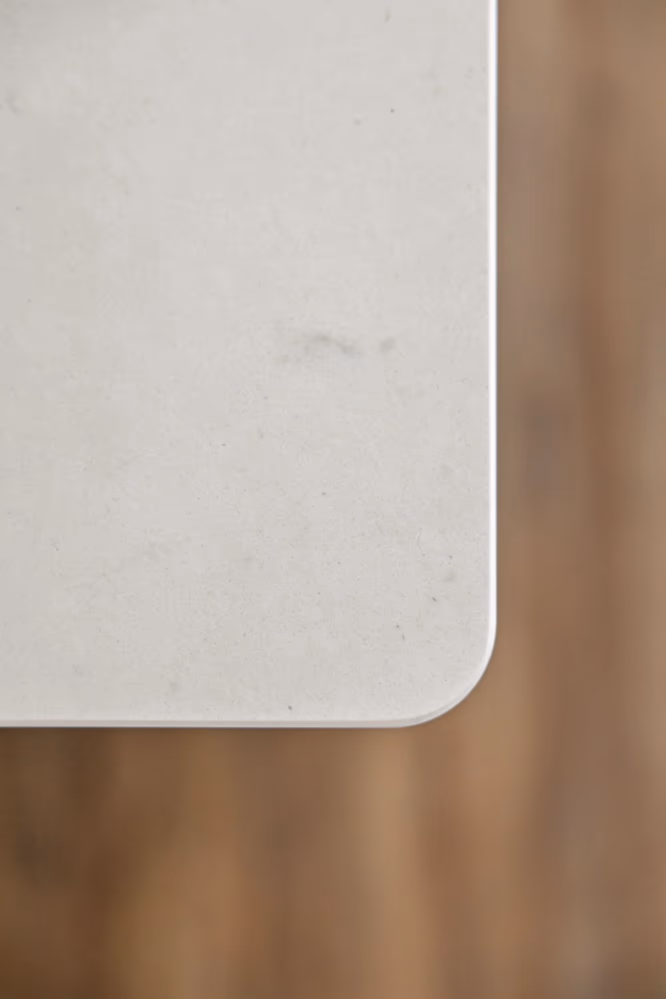 Close-up of a white kitchen countertop with wood edge.
