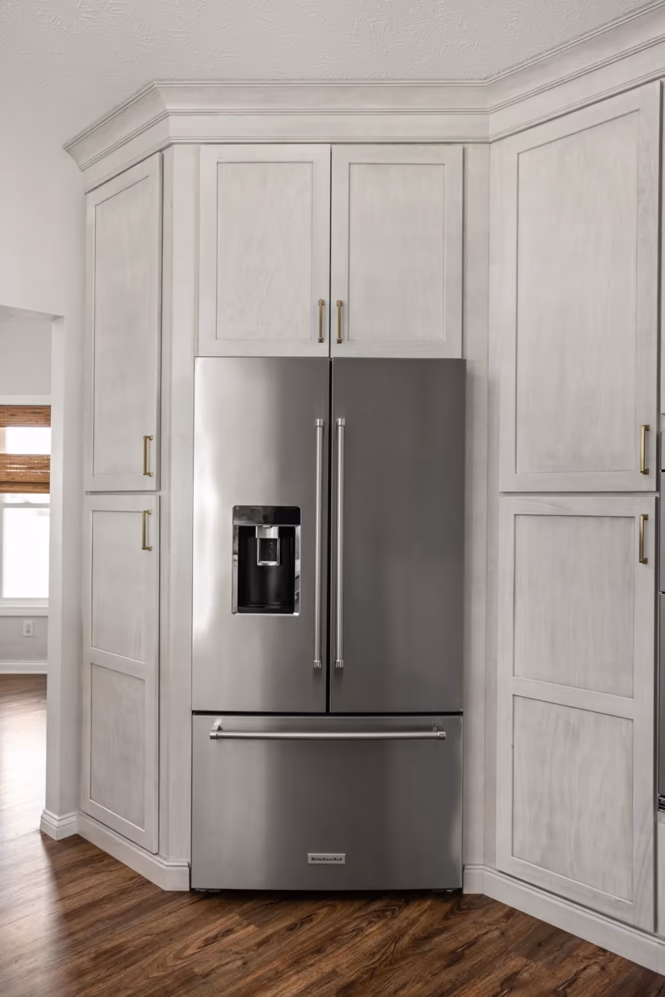 White kitchen wall with built-in oven and fridge