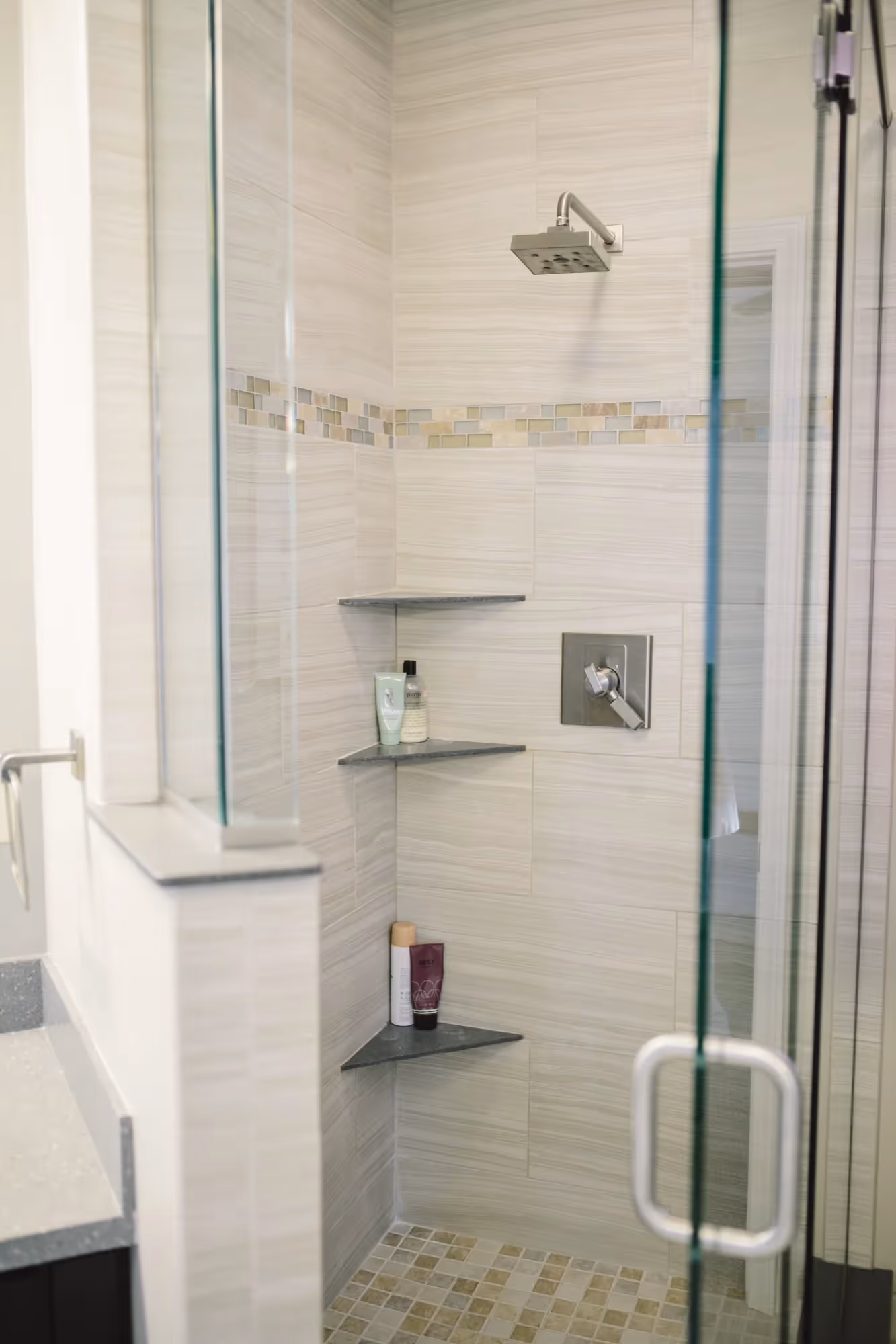 Glass-enclosed shower with tiled walls.