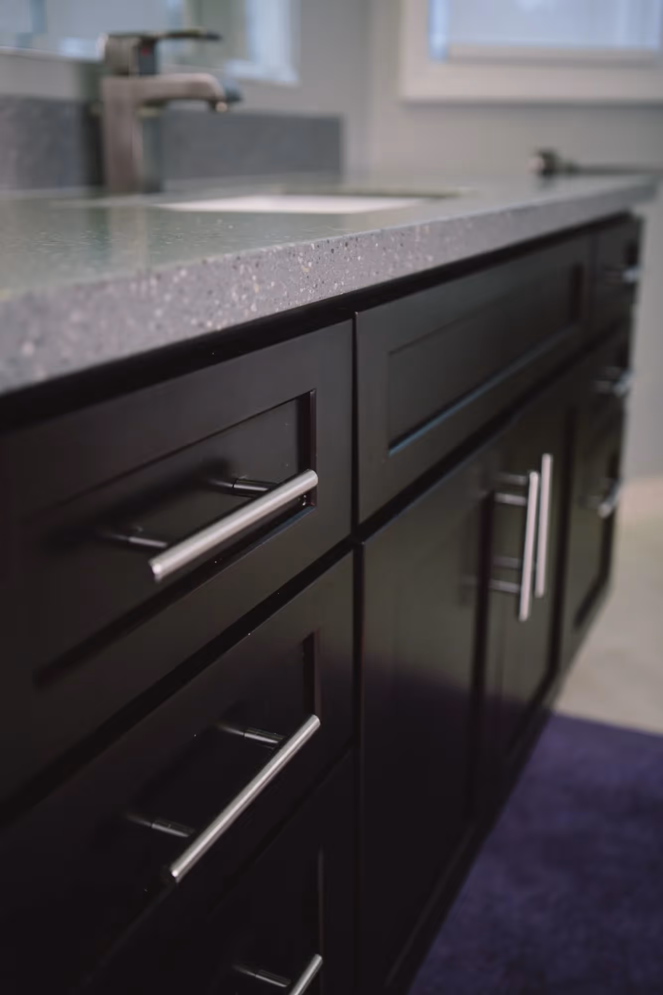 Bathroom vanity with dark cabinets and white countertop